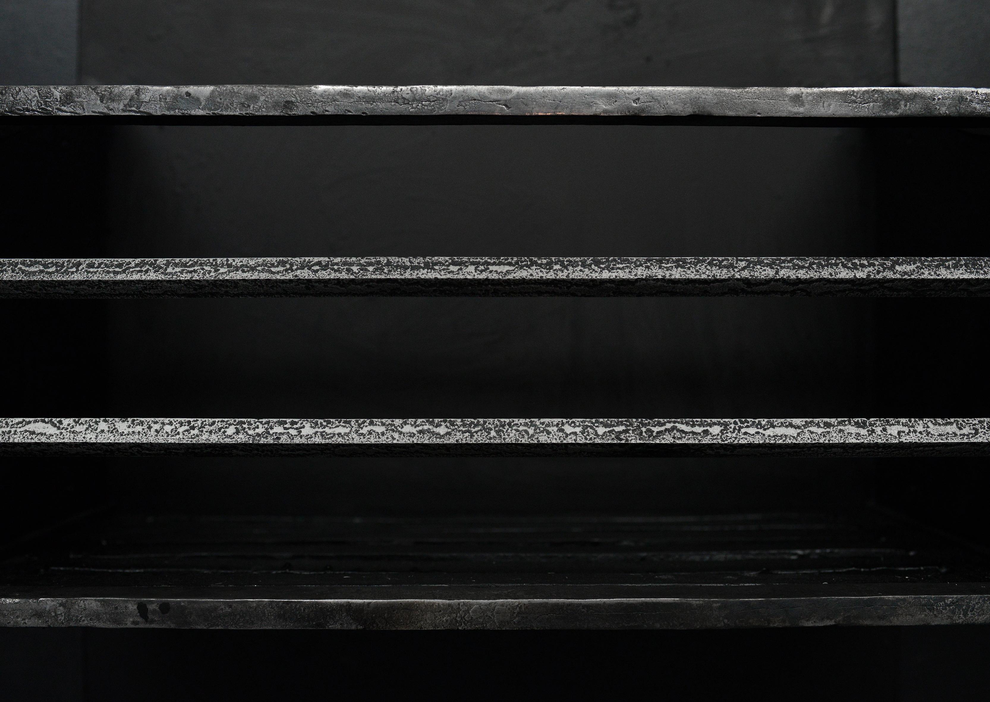 An understated burnish steel fire grate. Shown in antiqued finished, but also available in clean steel finish. Reproduction. 

N.B. May be subject to an extended lead time.

Measures:
Width At Front:	525 mm      	20 5/8 in
Width At Back:	520 mm     