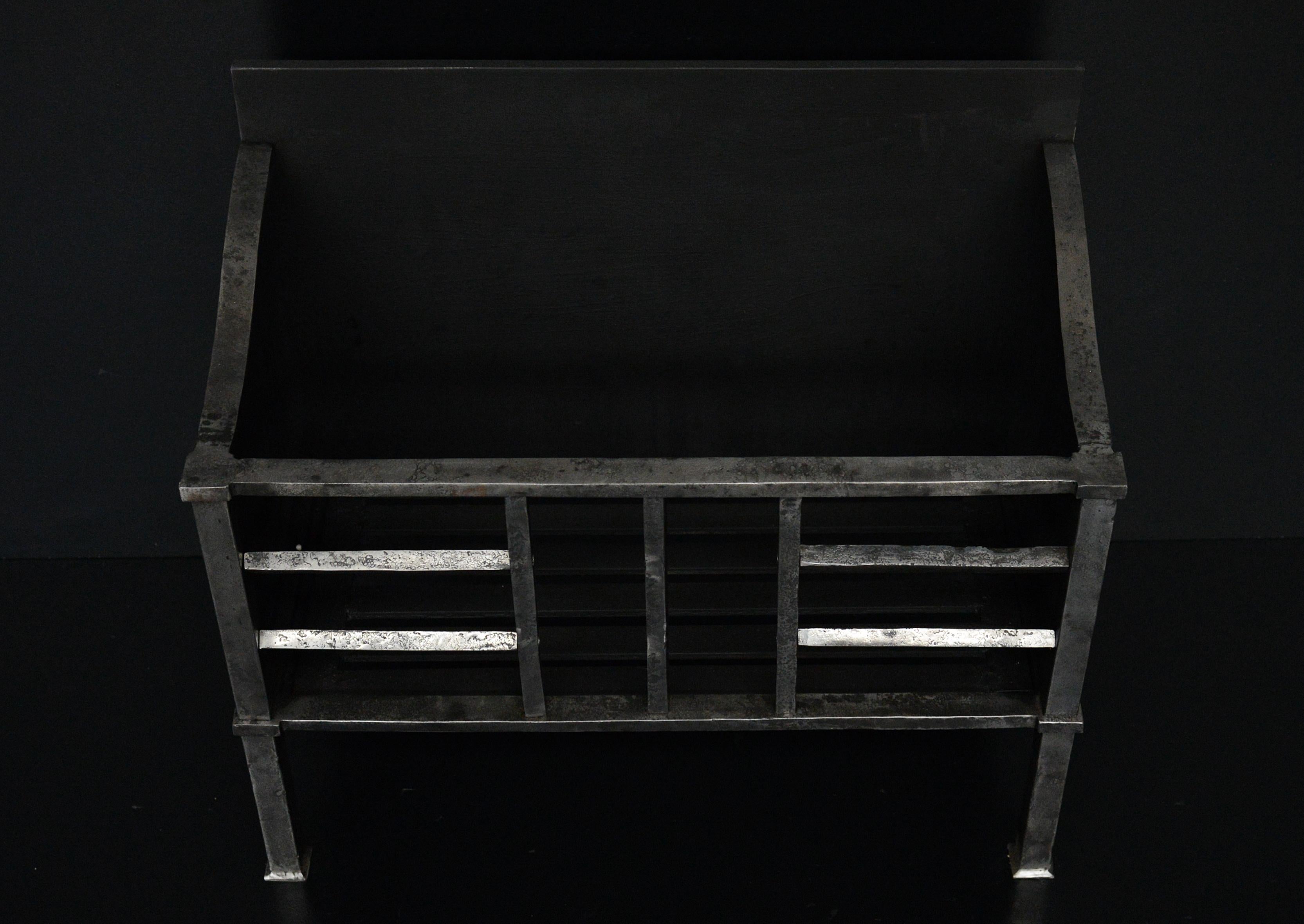 An understated burnish steel firegrate with upright bars to centre. Shown in antiqued finished, but also available in clean steel finish. Reproduction. 

N.B. May be subject to an extended lead time.

Width At Front:	610 mm      	24