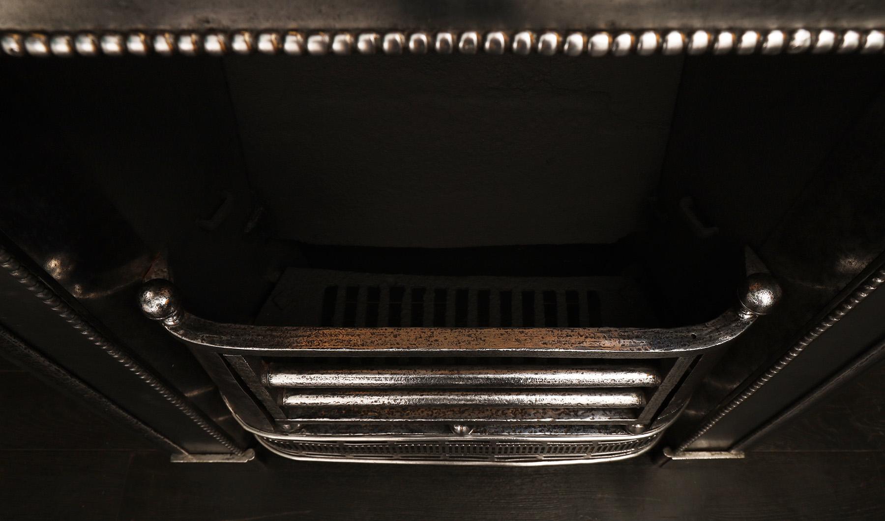 Grille de registre géorgienne en acier poli. L'encadrement de la façade est orné de moulures demi-rondes et de moulures en bourrelet. La façade courbée avec des plaques de cuisson et des épis de faîtage en forme de boule, le tout surmonté d'une