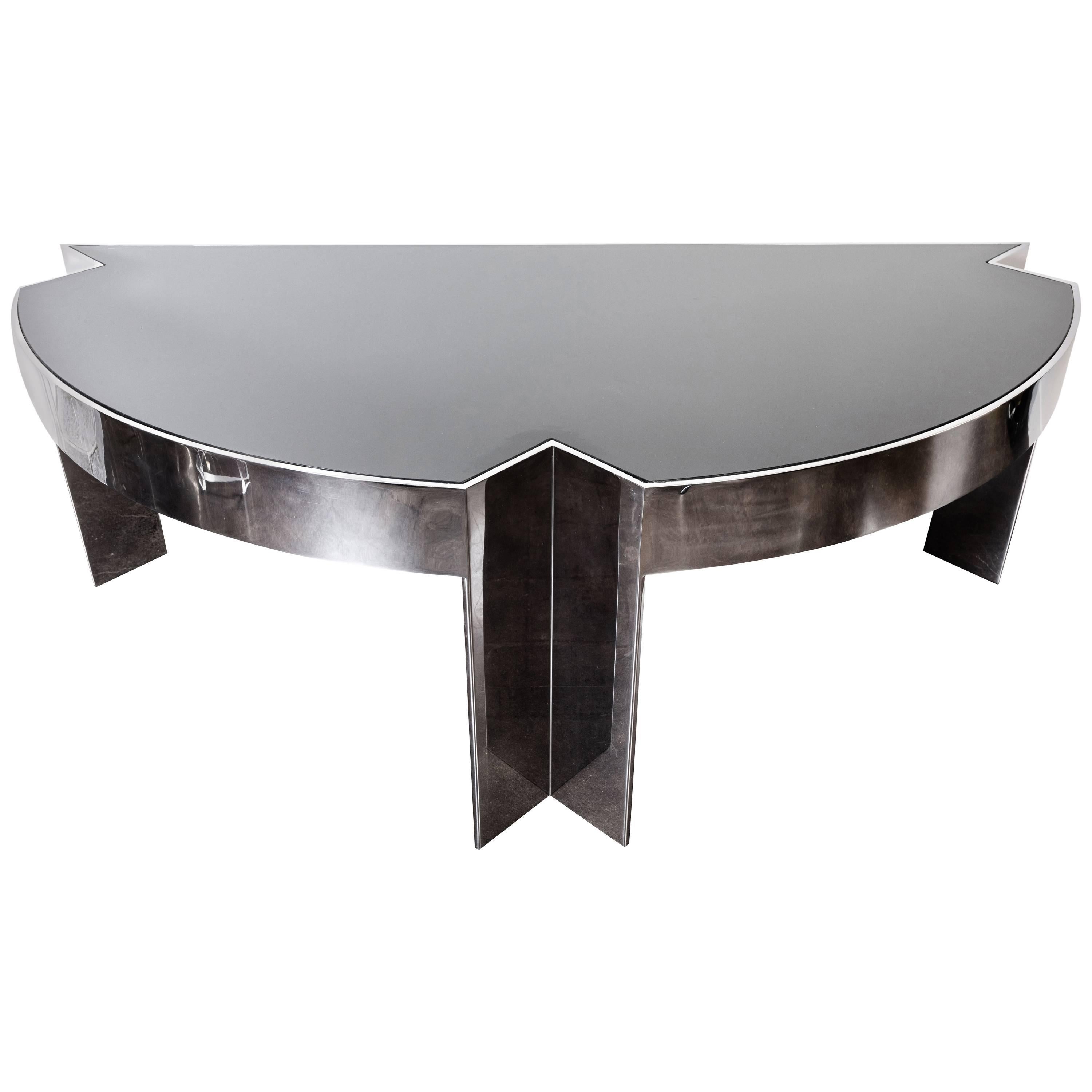 Monumental and fabulous polished steel executive desk by Leon Rosen for Pace, early 1970s. Desk has a half round shape with two drawers on one side, supported by three legs and a black glass top. The desk is in remarkable condition for its age, with