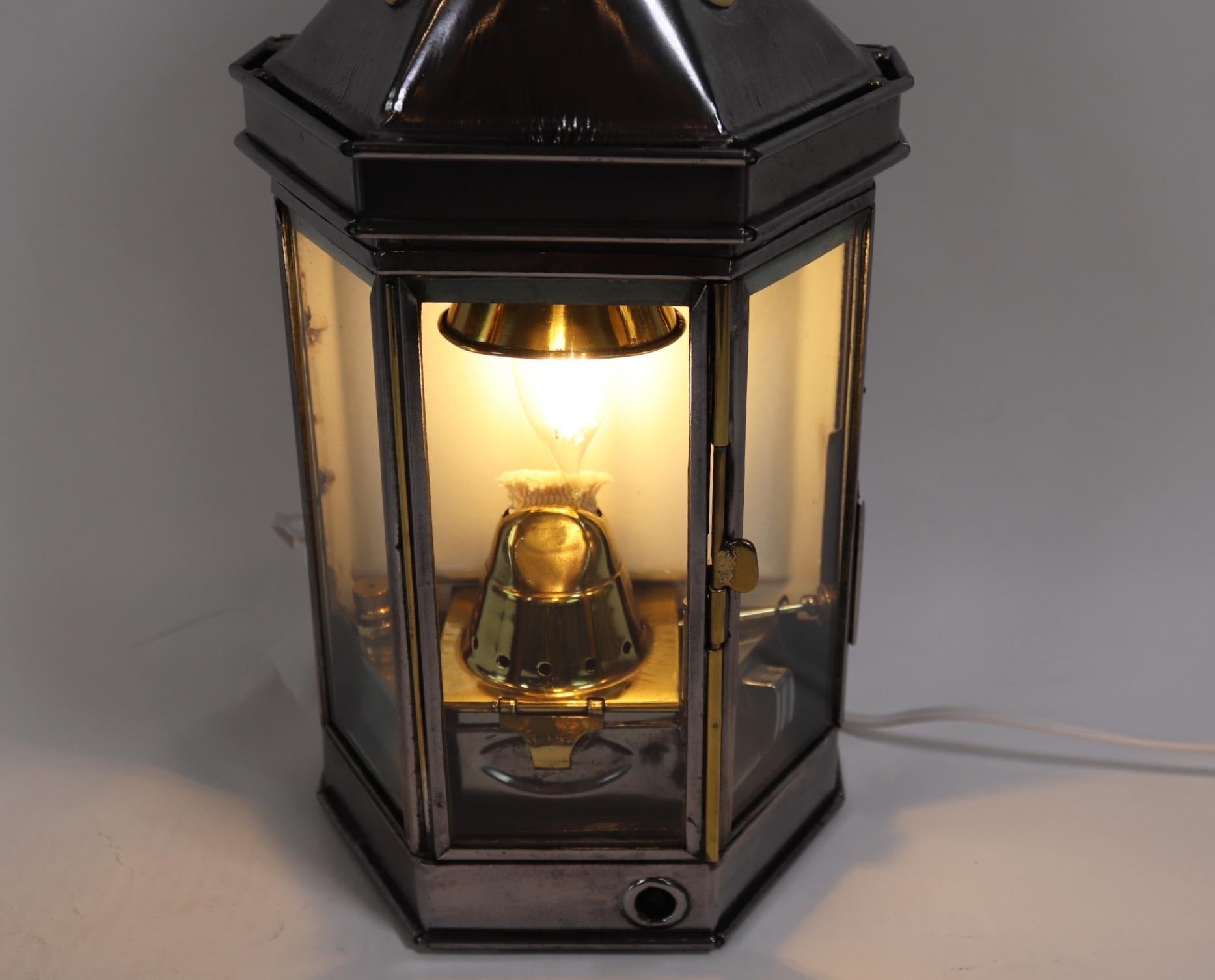 Polished steel cabin lantern from a ship or yacht. Sturdily built with carry handle, three glass panes, and original burner. The lantern has been wired for home display. Weight is 10 pounds.