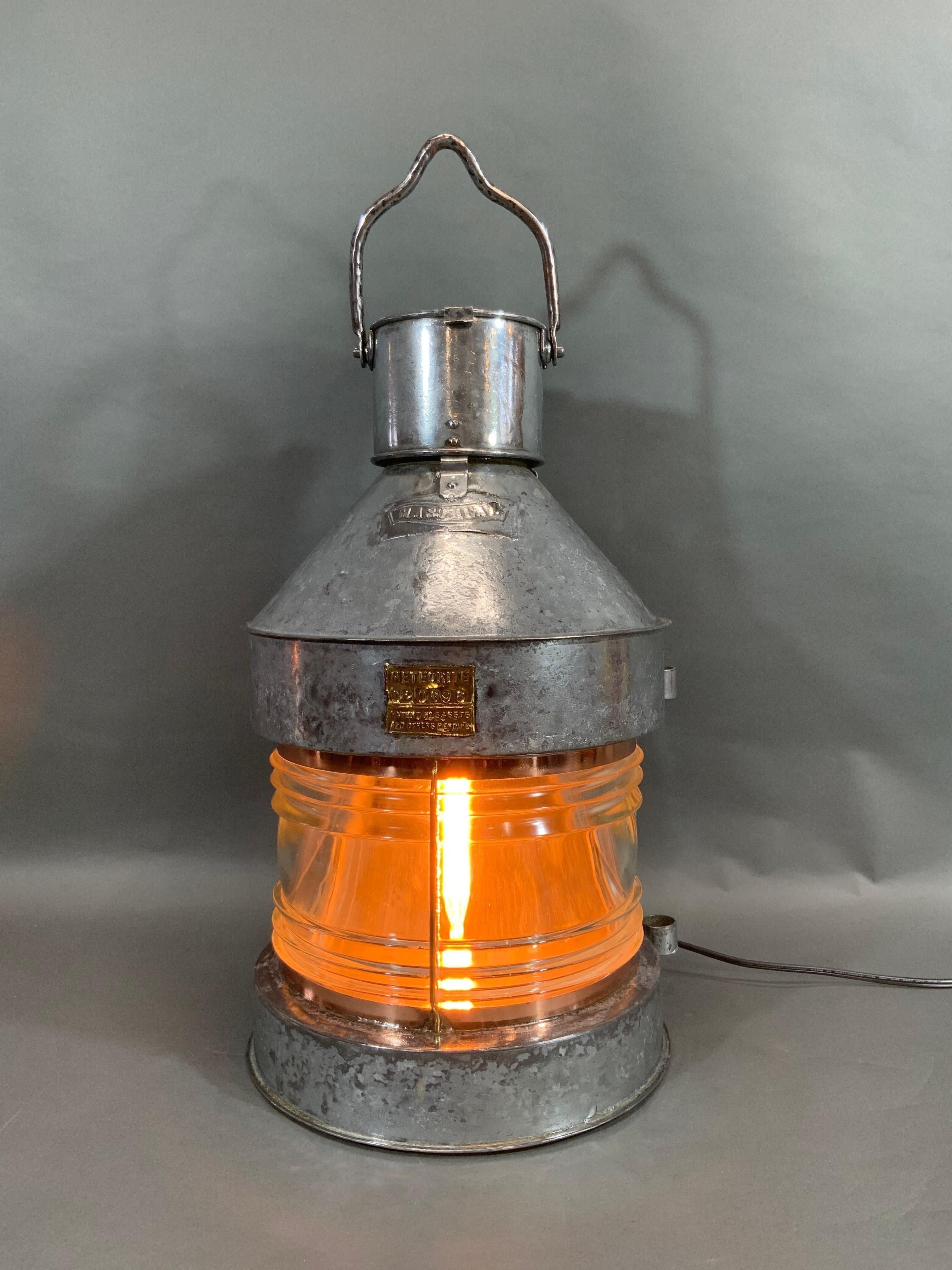 Awesome antique ship's masthead lantern with Fresnel glass lens. Hinged and vented top. Brass makers badge with serial number C20696 from English Maker Meteorite. Sturdy hoisting handle. Circa 1925. Wired for home use.

Overall Dimensions: 23