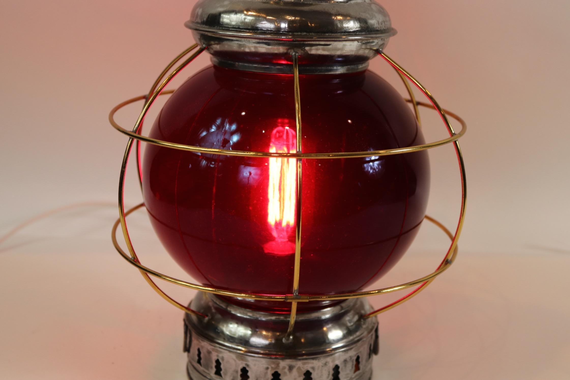 Ship's polished and lacquered onion lantern with protective brass bars, ruby red lens, new socket and wired for home display.

Overall dimensions: Weight is 6 pounds. 18