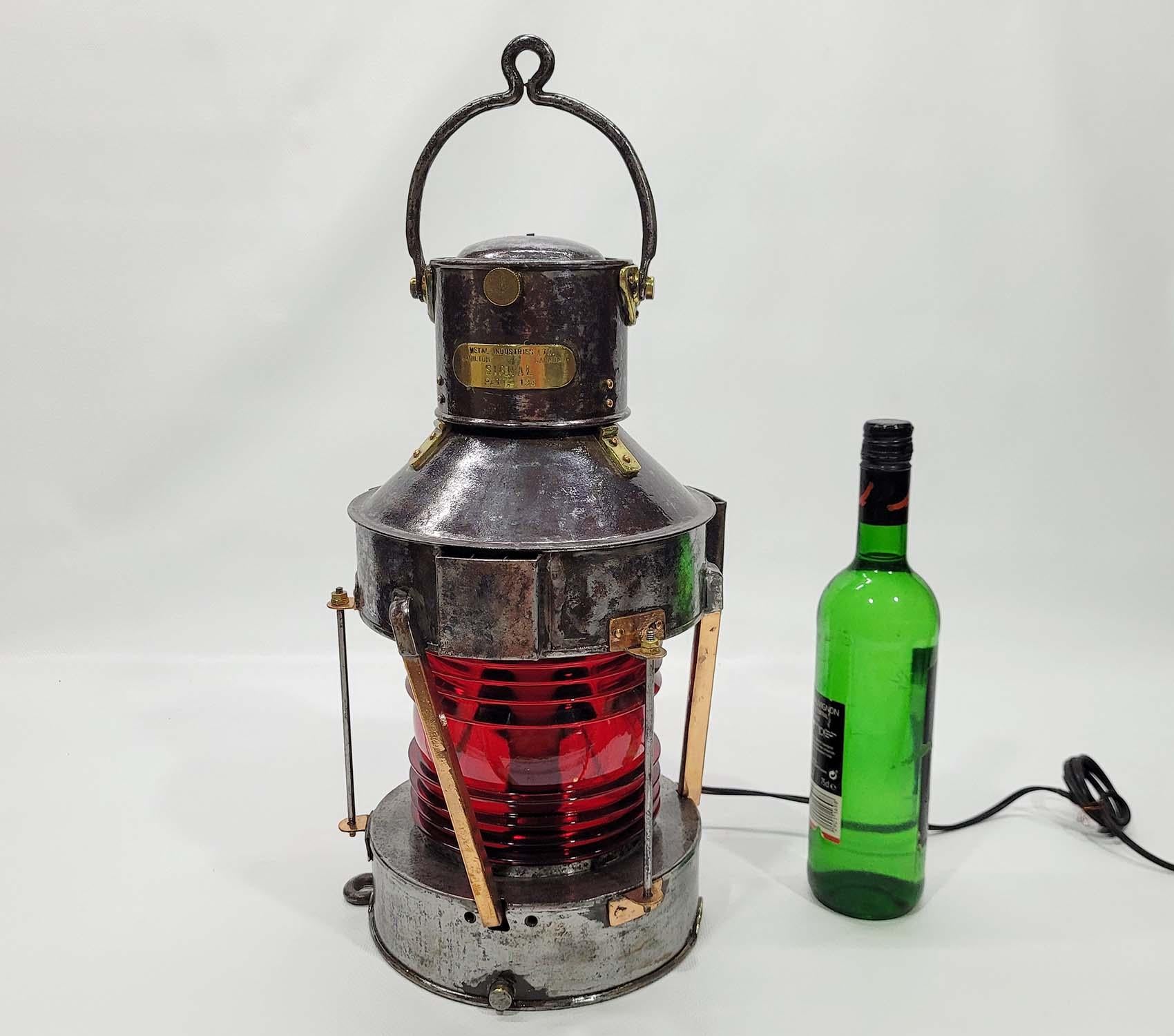 Steel cased ships lantern with brass and copper elements. Copper bars protect the ruby red Fresnel lens. Brass hinges on carry handle and chimney mounts. Wired with electric socket. Heavy hoisting handle. Circa 1950

Weight: 8 lbs.
Overall