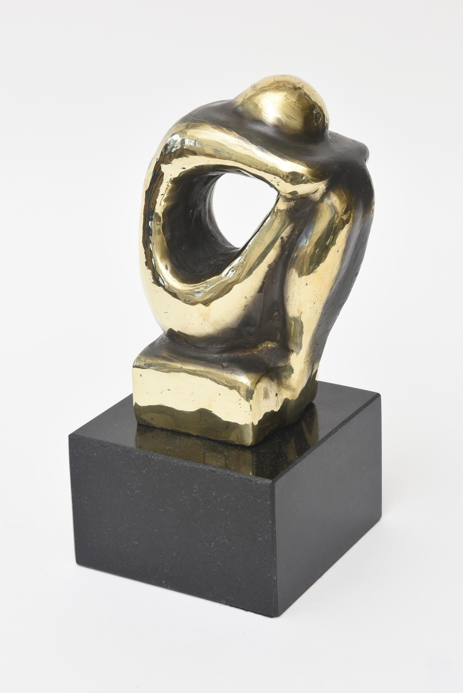 This arresting and handsome seated male figurative abstract brass and black granite sculpture is handsome and powerful. It is Spanish and is a limited edition number. Part of the brass has been polished and the remainder is a beautiful two-tone