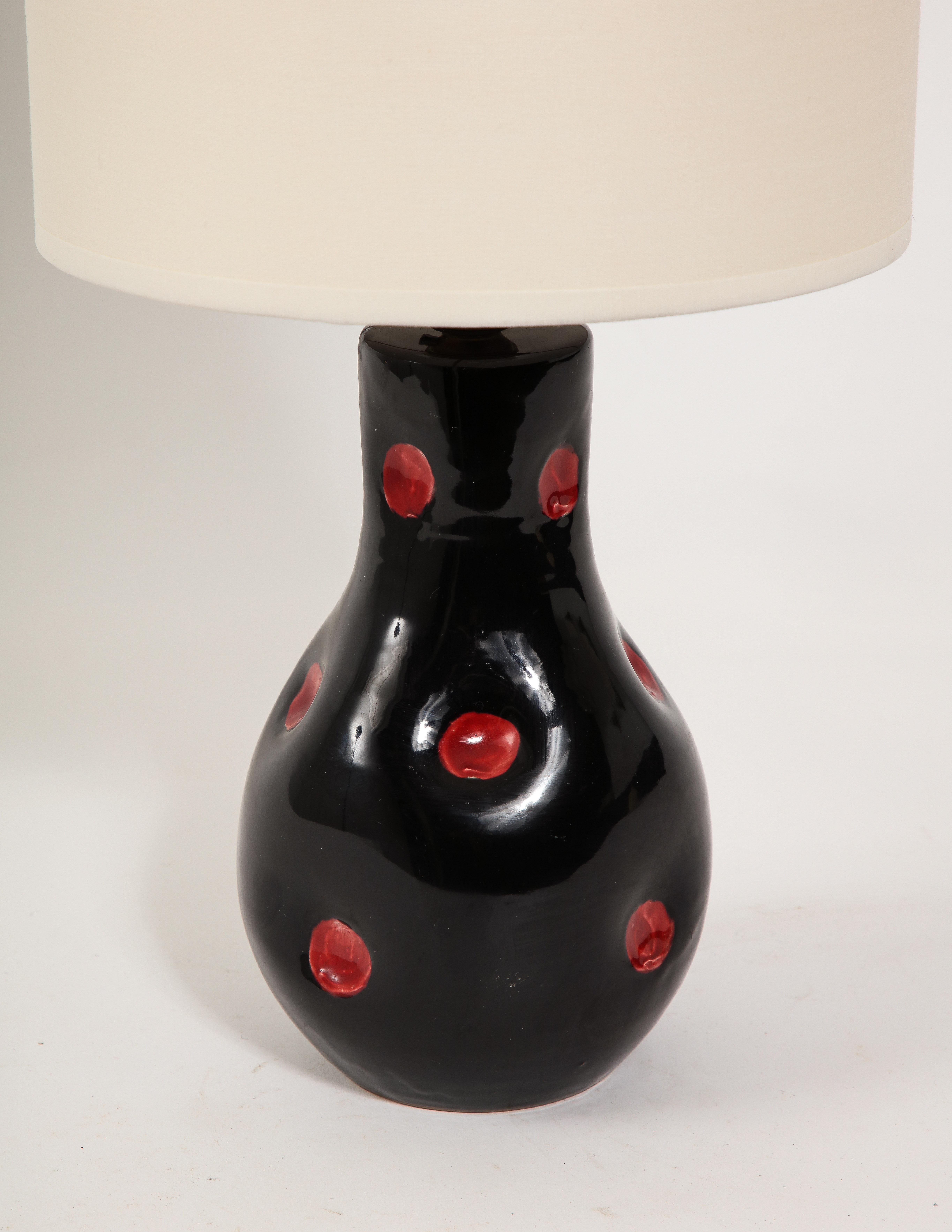 Black glazed ceramic lamp with a dimple decor accentuated by red glaze dots.

11x5x5 Base Only