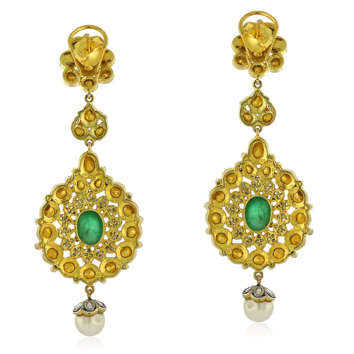 This earring set with emerald and pearl made in gold and silver is a piece of jewelry that features a combination of polki diamonds, emeralds, and pearls set in a gold and silver earring design. Polki diamonds are uncut diamonds that are