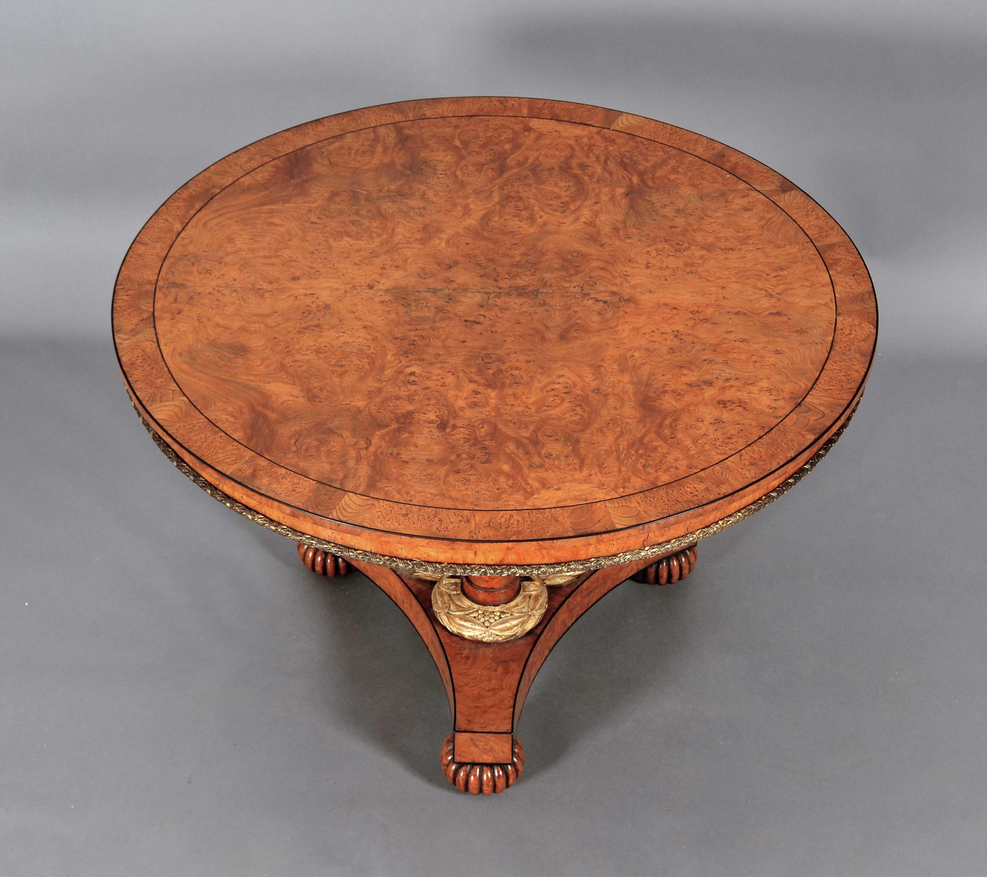 Mesa de centro de roble barnizado del periodo de la Regencia. La parte superior está chapada en madera, con listones cruzados e incrustaciones de cuerda ebonizada. Con una moldura de latón coronado a lo largo del borde inferior. El pedestal de