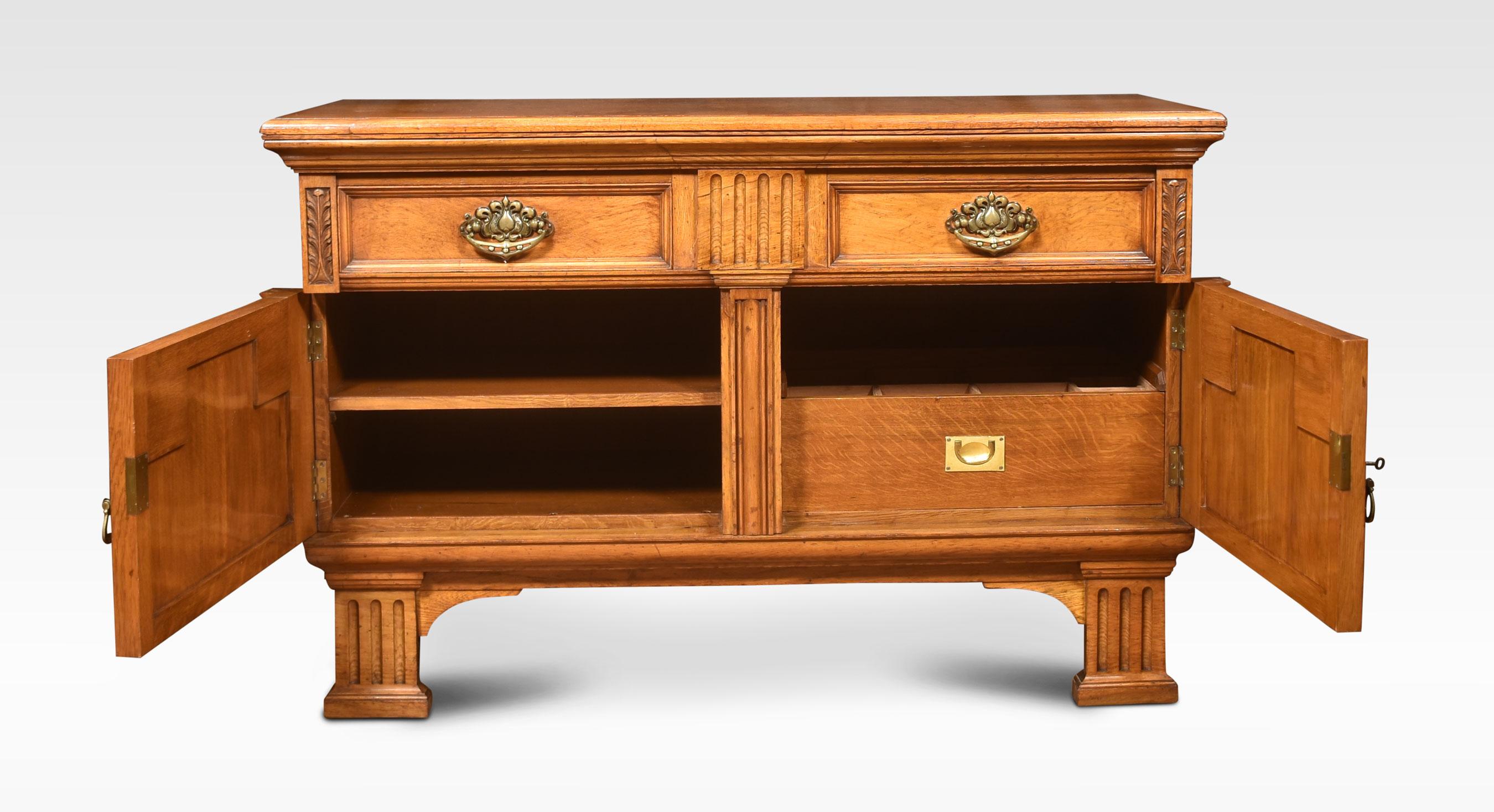 19th Centuary sideboard, the large rectangular pollard oak top above two frieze drawers with bold tooled brass handles. Above a pair of panelled doors with crisp carved detail, openeing to reveal shelving and a cellaret. All raised up on reeded