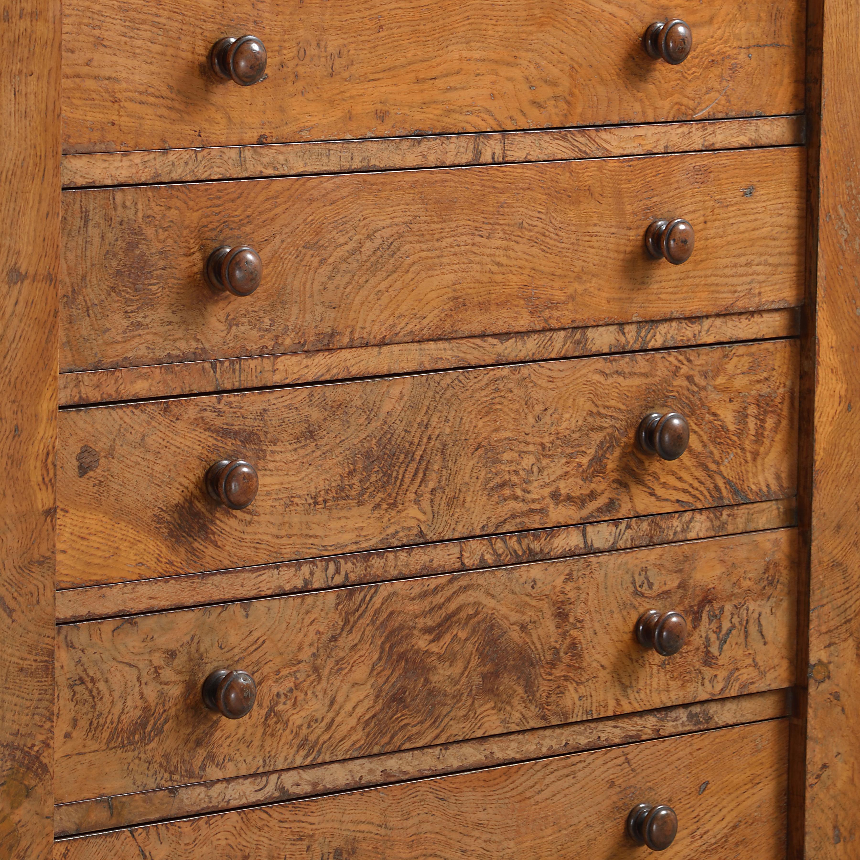 A fine early Victorian pollard oak Wellington chest, with eleven cedar-lined drawers, circa 1840. 

Labelled: Alexander Grant & Son, Cabinet Makers, Liverpool.