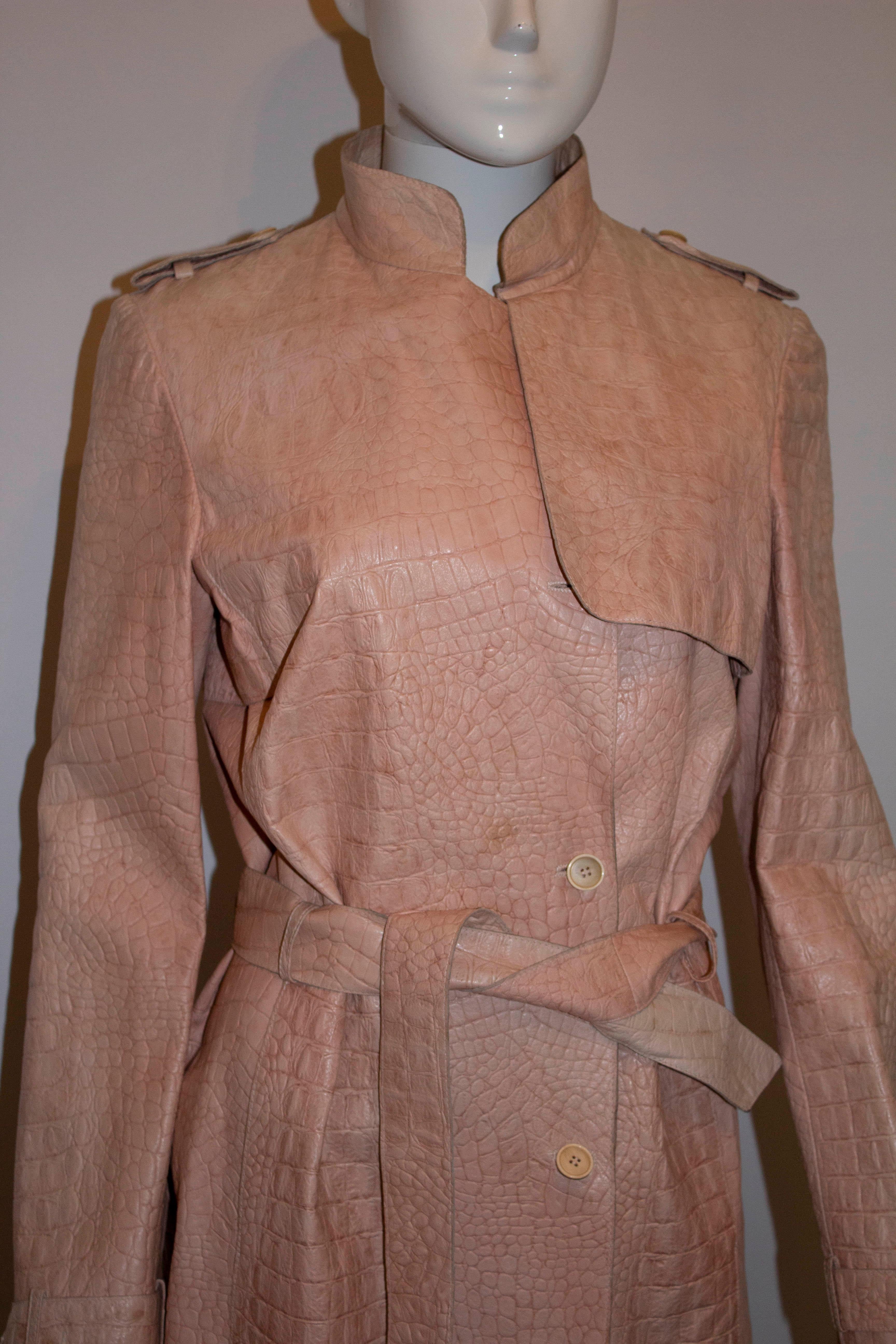 A chic leather trench coat for Spring / Summer by Pollini.  In a pretty pink stamped leather, crocodile effect, the coat is fully lined with a leather belt.  Measurements: Bust 36'', waist 29'', length