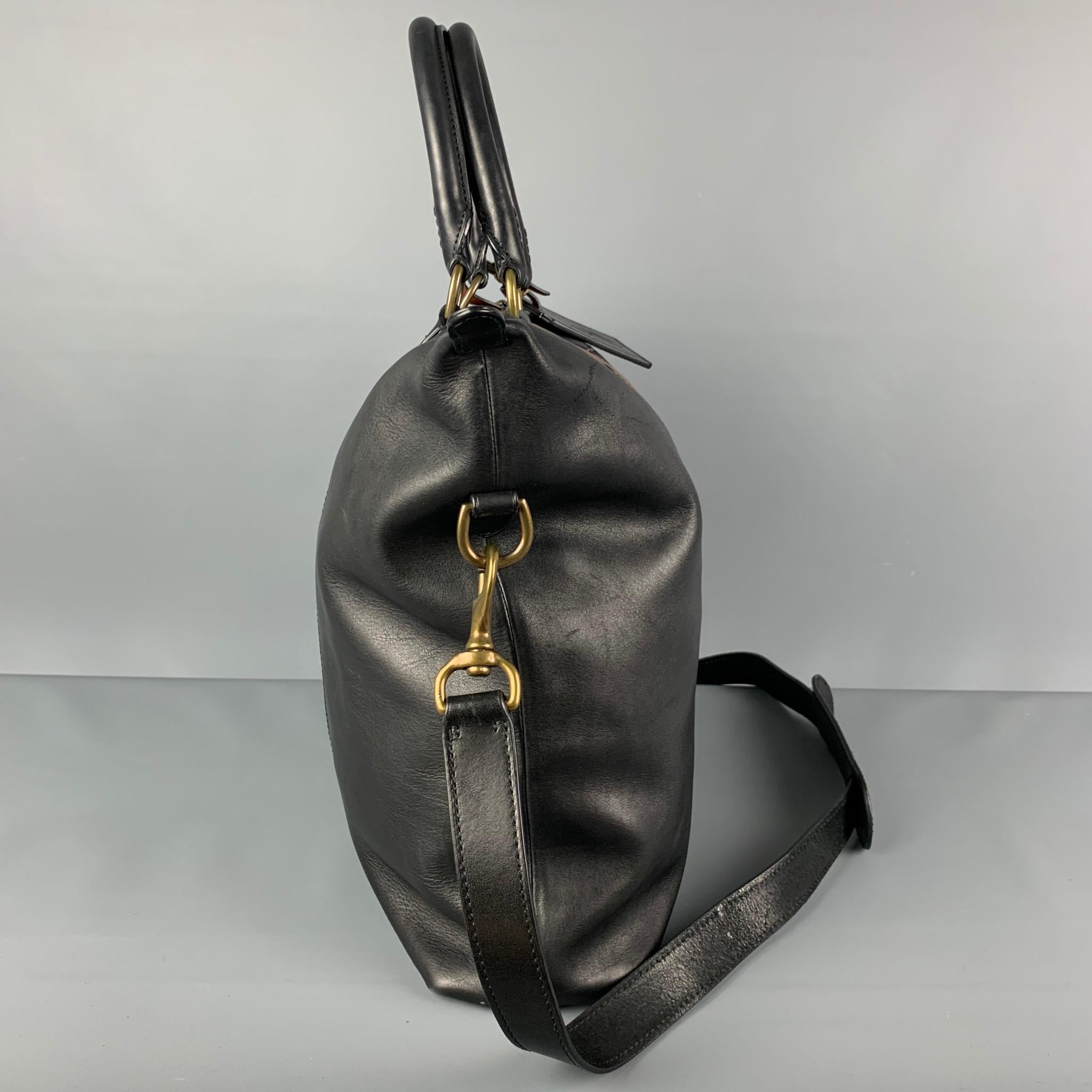 POLO by RALPH LAUREN tote bag comes in a black & brown color block leather featuring brass hardware, top handles, detachable shoulder strap, interior pockets, and a top zipper closure. 

Very Good Pre-Owned Condition. Light