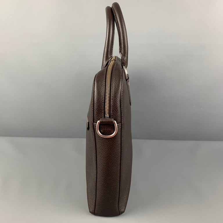 POLO by RALPH LAUREN briefcase comes in a brown pebble grain leather featuring a top handle, front exposed pocket, silver tone hardware, and a zip up closure. 

Very Good Pre-Owned Condition.

Measurements:

Length: 15 in.
Width: 2 in.
Height: 11.5