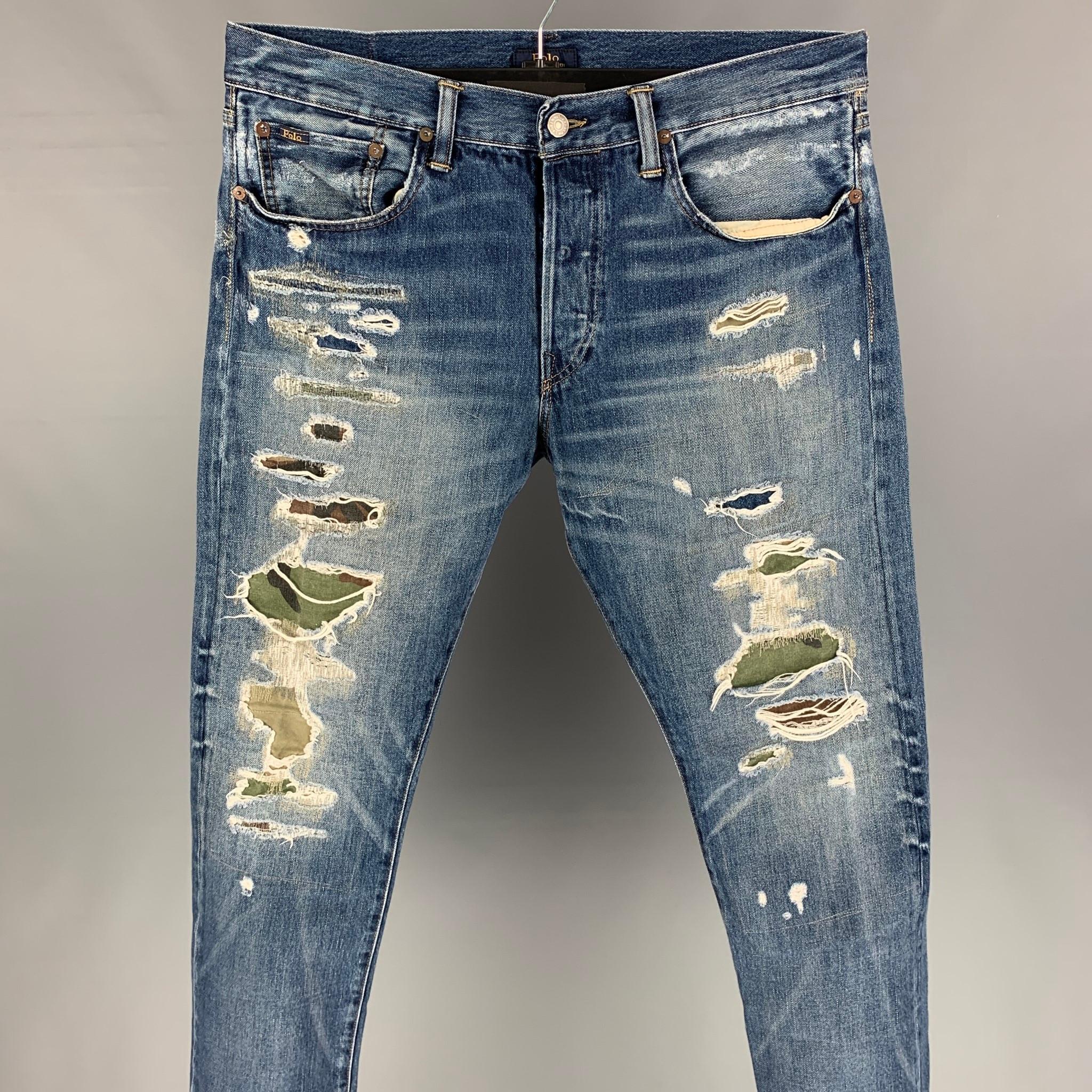 POLO by RALPH LAUREN jeans comes in a indigo distressed denim featuring a slim fit, camouflage trim, contrast stitching, and a button fly closure. 

Very Good Pre-Owned Condition.
Marked: 33x30

Measurements:

Waist: 33 in.
Rise: 11 in.
Inseam: 30