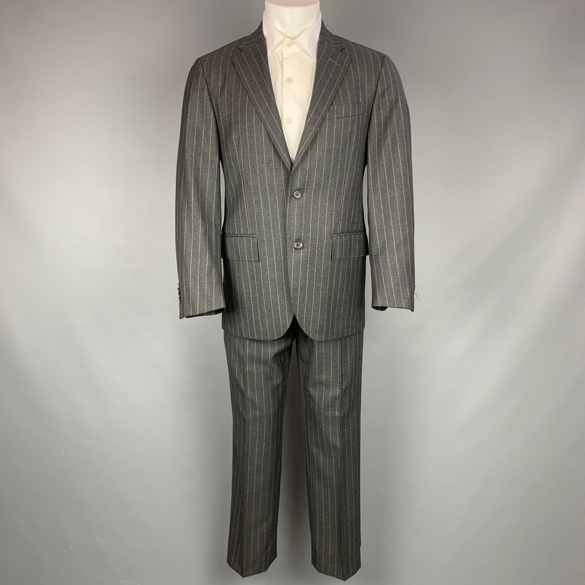 POLO by RALPH LAUREN suit comes in charcoal & grey pinstripe wool blend with a full liner and includes a single breasted, double  button sport coat with notch lapel and matching flat front trousers. Made in Italy.

Very Good Pre-Owned