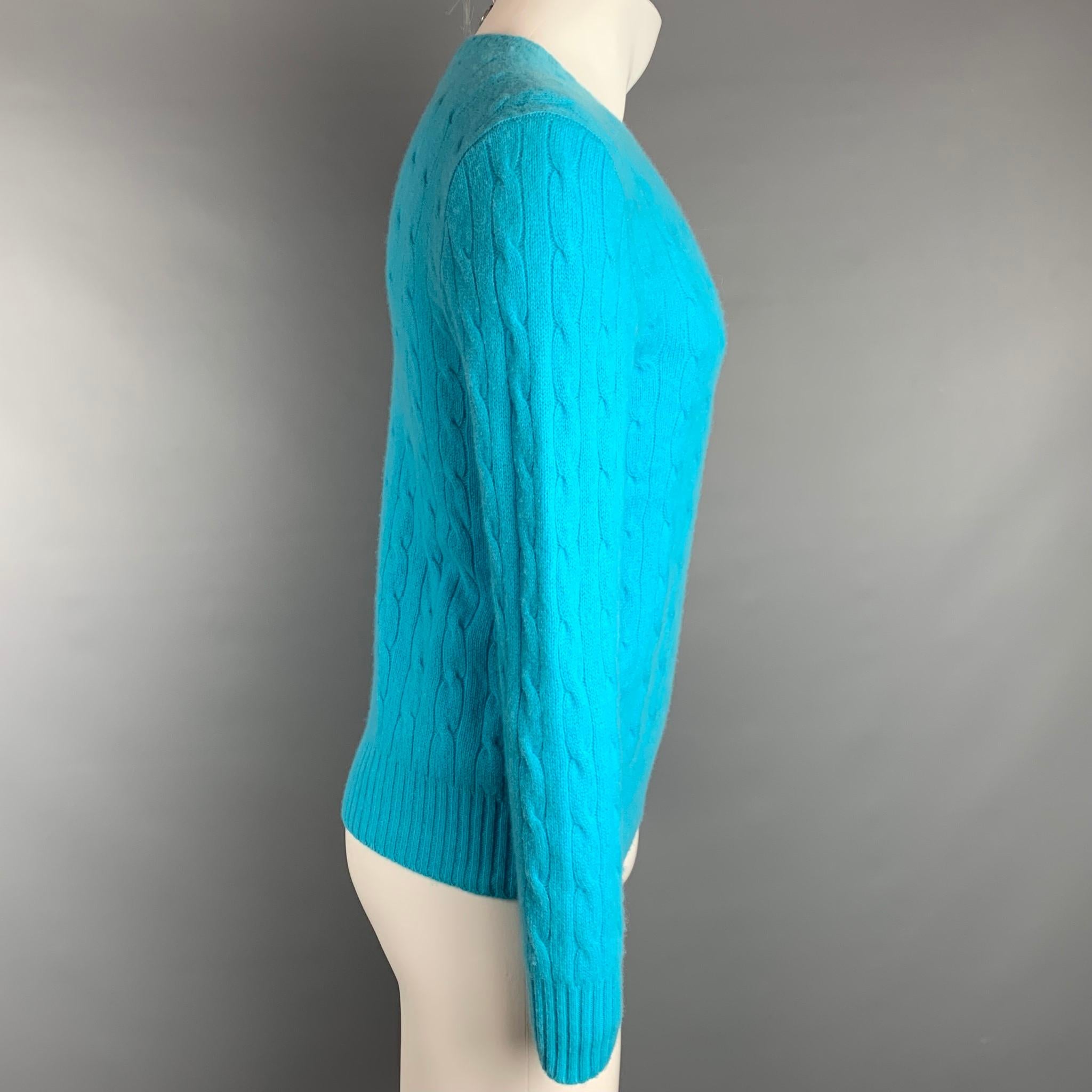 POLO by RALPH LAUREN pullover comes in a aqua cable knit cashmere featuring a crew-neck.

Very Good Pre-Owned Condition.
Marked: L

Measurements:

Shoulder: 18 in.
Chest: 40 in.
Sleeve: 26.5 in.
Length: 23 in. 