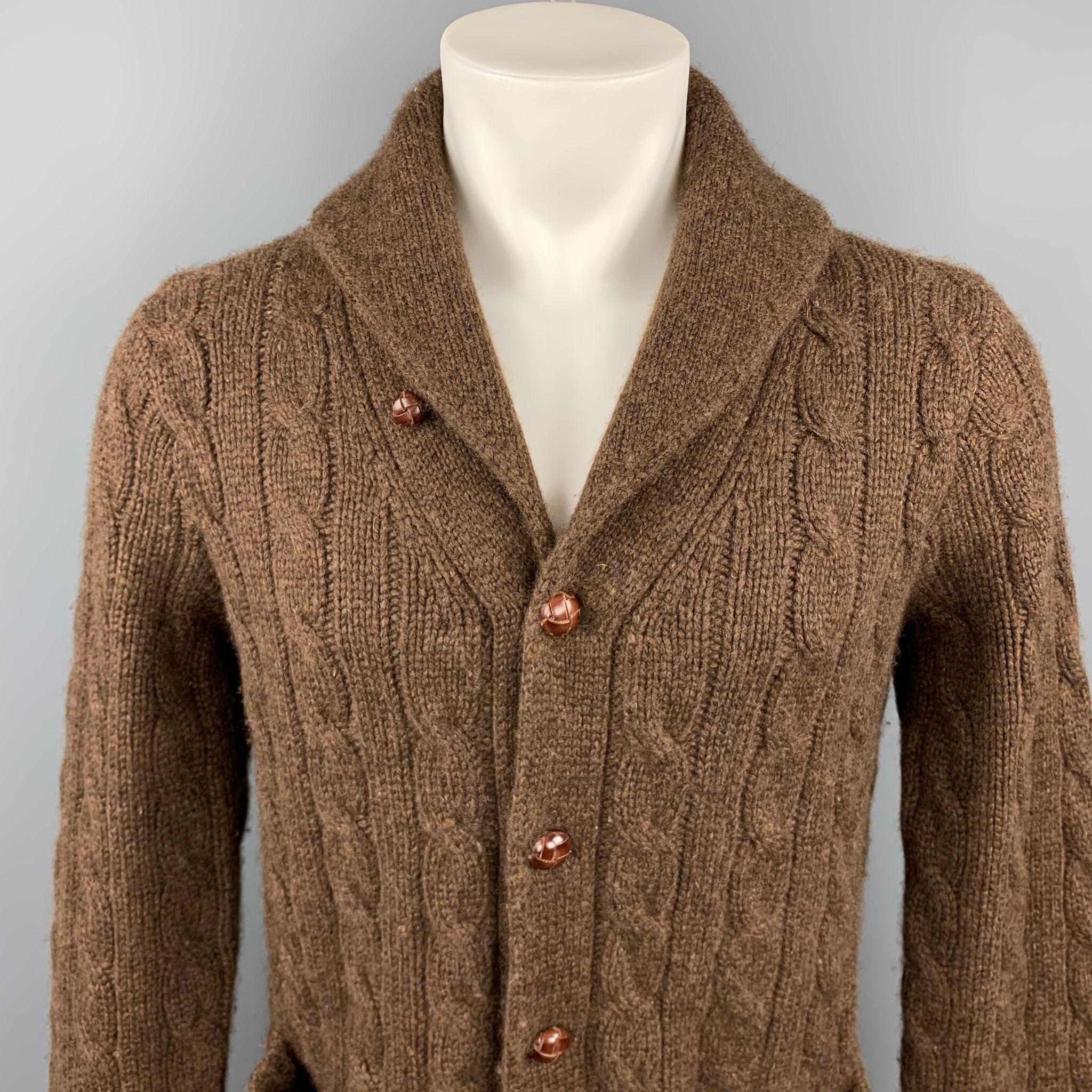 POLO by RALPH LAUREN cardigan comes in a brown cable knit cashmere featuring a shawl collar, front pockets, and a buttoned closure.

Excellent Pre-Owned Condition.
Marked: M

Measurements:

Shoulder: 17 in. 
Chest: 40 in. 
Sleeve: 29 in. 
Length: 27