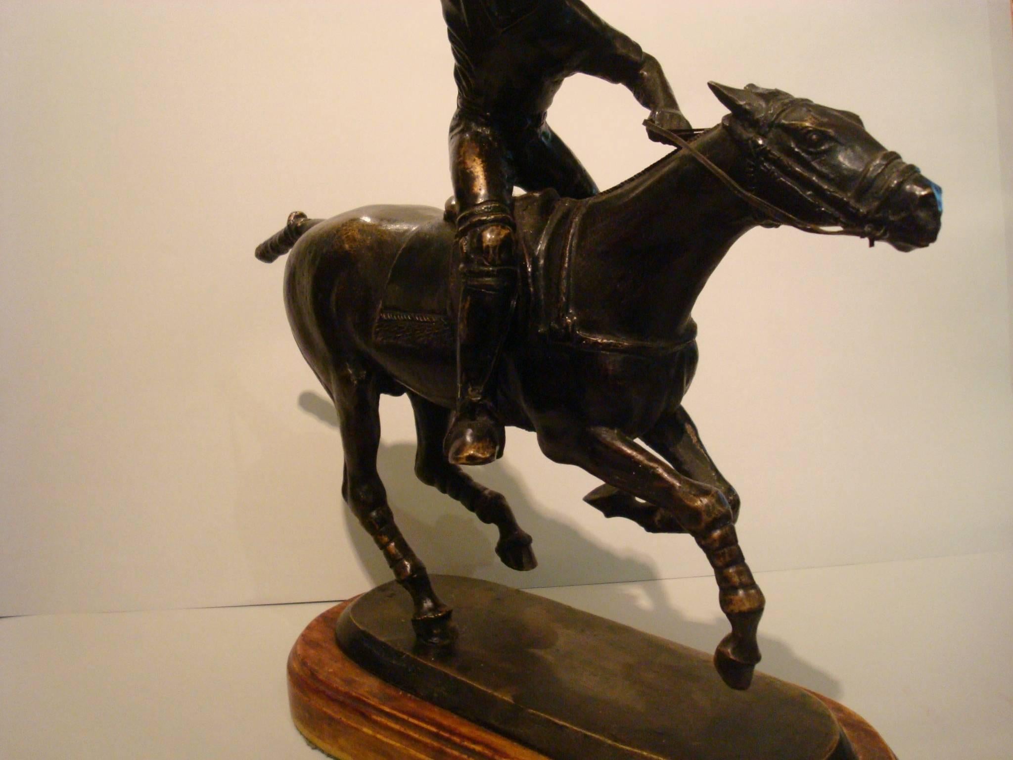 Very nice bronze sculpture of a Polo player over its horse in a match movement.
High detailed. Perfect for a trophy. The figure is mounted over a resin base, that looks like wood.