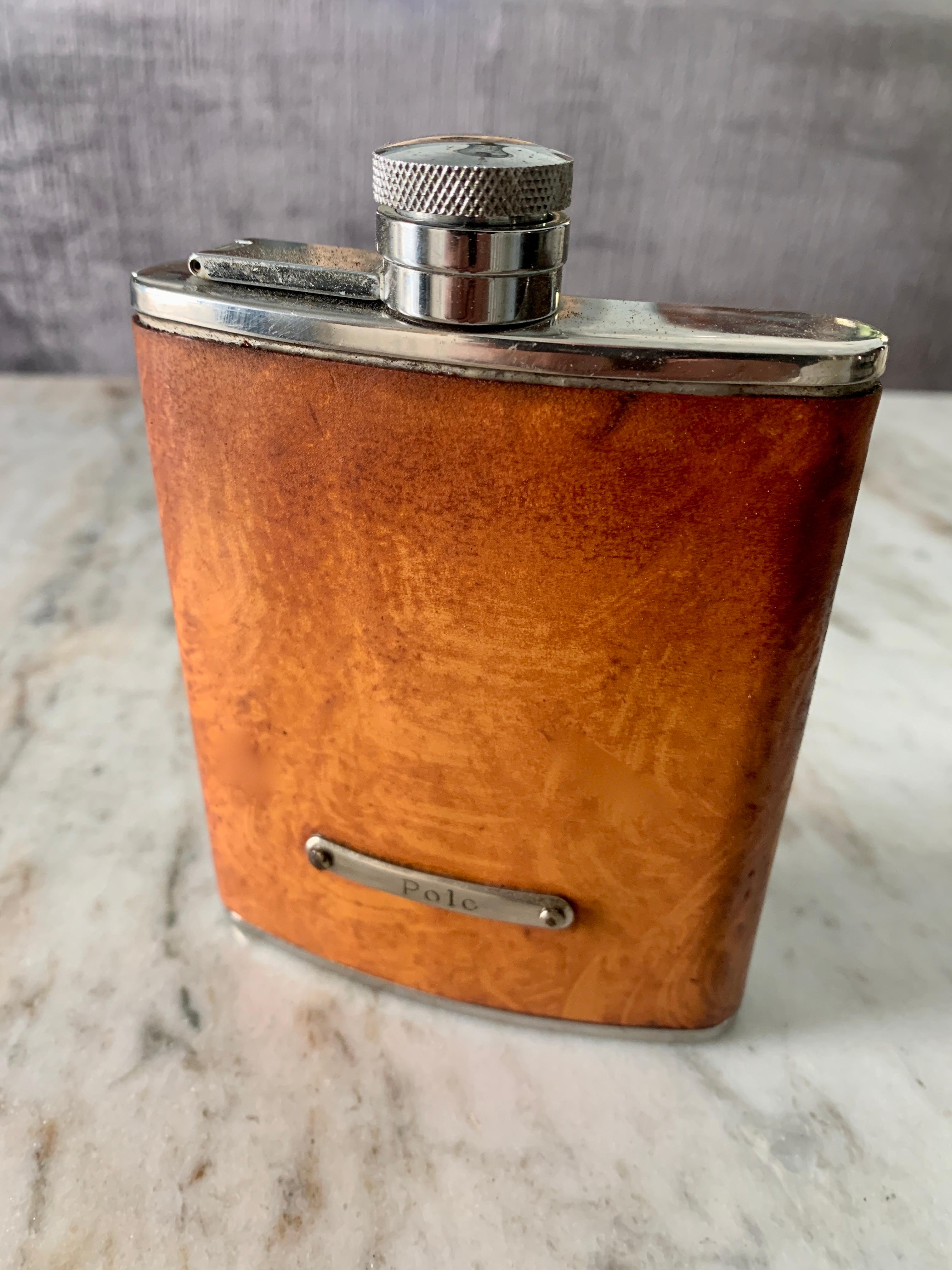 Patinated leather flask with hand stitching and polo emblem on front. The stainless steel cap unscrews but stays attached... have a night cap and don't lose your cap! Fits wonderfully in any coat, or pant pocket... or in your purse! 

The