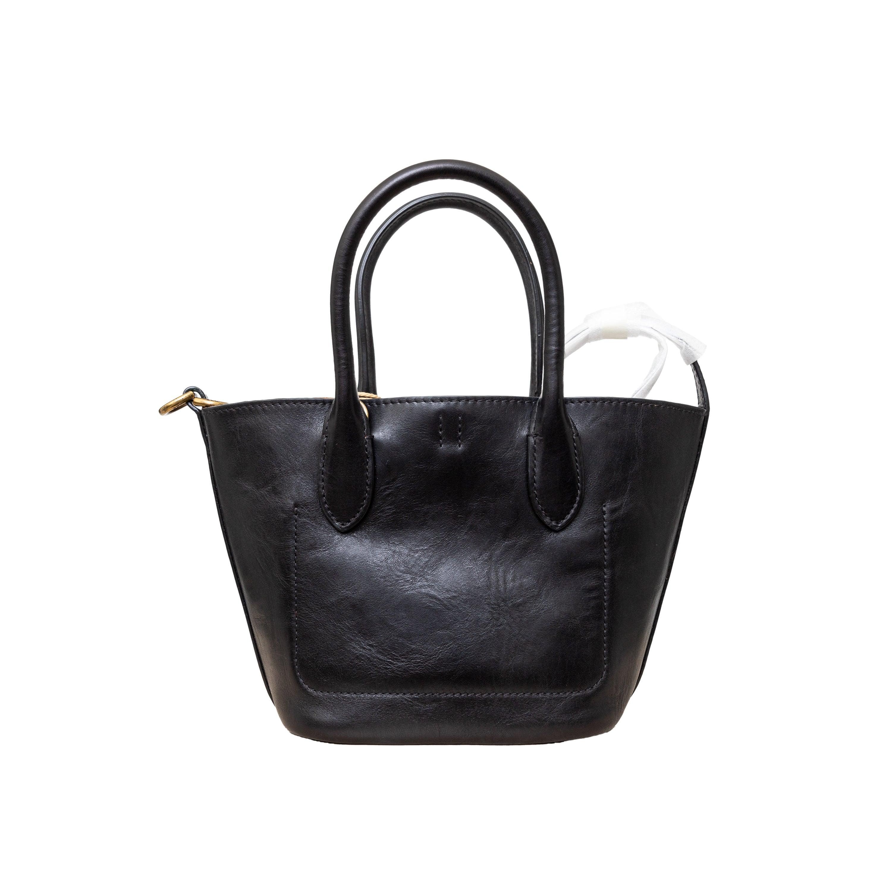The Polo Ralph Lauren Mini Bellport Tote Bag is expertly crafted from luxurious Italian calfskin leather, providing both durability and sophistication. The trapezoid-shaped silhouette and suede interior offer a perfect balance of flexibility and