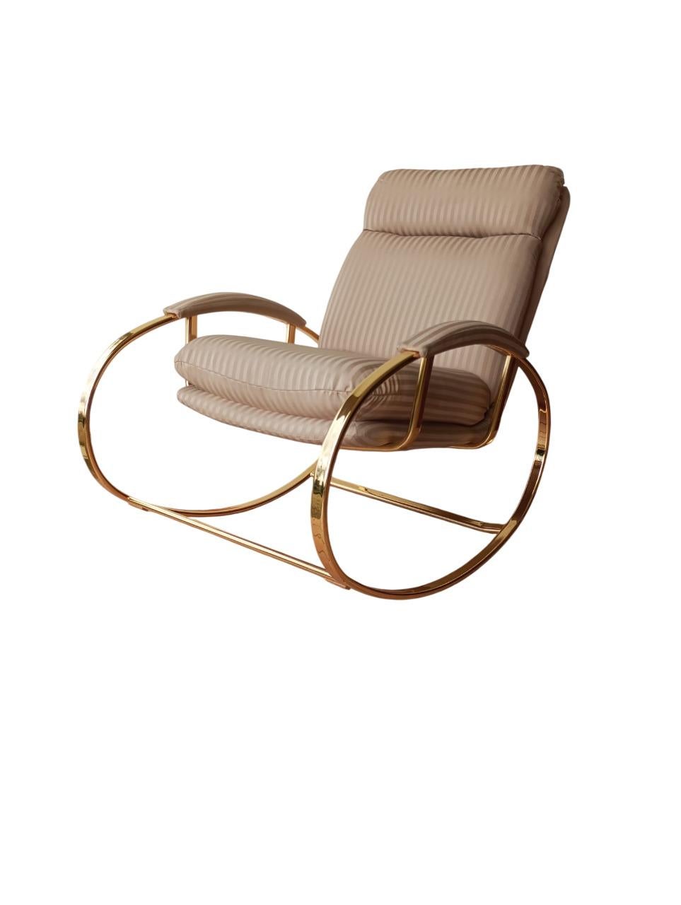 Raffinata sedia a dondolo italiana disegnata da Guido Faleschini negli anni '70, realizzata in ottone con cuscino originale in tessuto.
La struttura in ottone, elegante e solida, dialoga armoniosamente con le linee sinuose del design. 
Guido