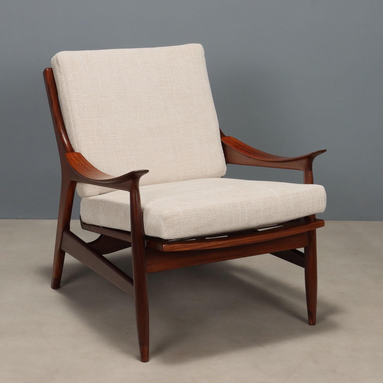 Poltrona vintage  con estructura de madera de teca a la vista, cojines del asiento y del respaldo que se deslizan sobre correas de tessuto ligeramente rayadas en los tonos del blanco panna. Poltrona restaurada en nuestros laboratorios.