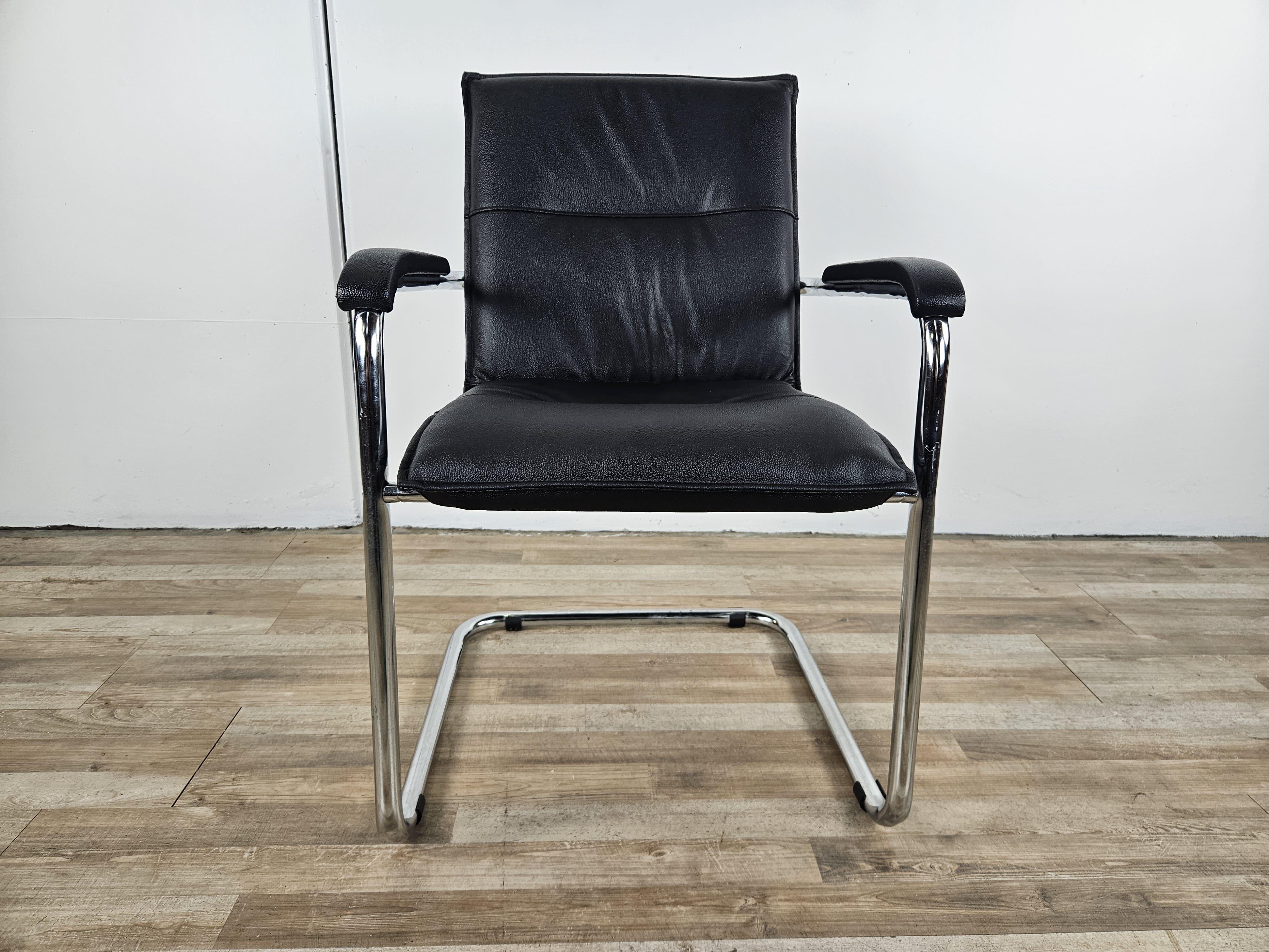 Office armchair circa 1970s with tubular steel frame and upholstered in vintage original black faux leather.

Seat and backrest as far as possible were cleaned and polished with special professional product.
Slight stain as pictured at bottom of