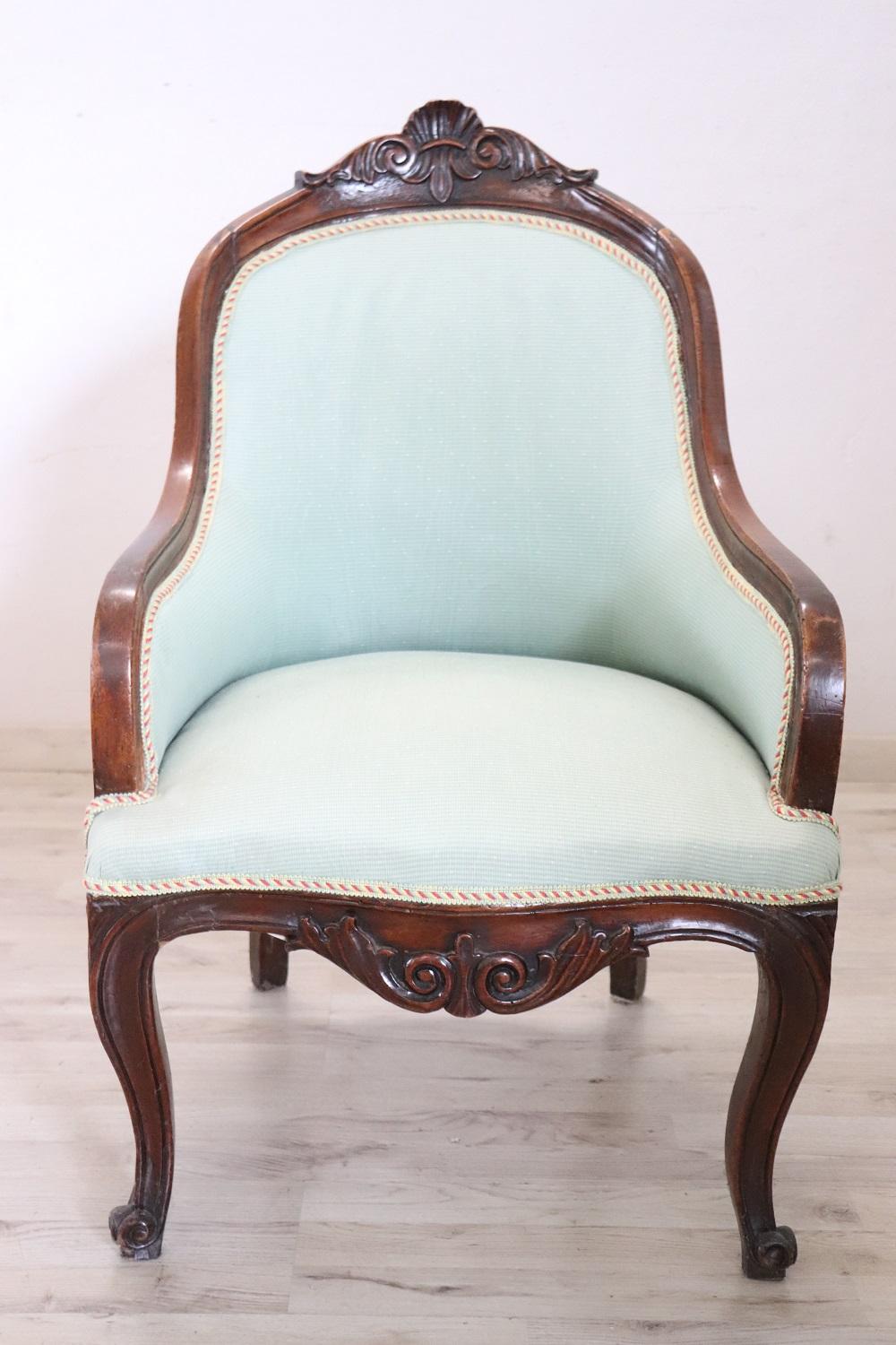 Delightful small antique Italian armchair from the mid-19th century Louis Philippe period. Made of solid walnut wood with refined wood-carved decoration. Small size very comfortable and enveloping with padded backrest. These small armchairs were