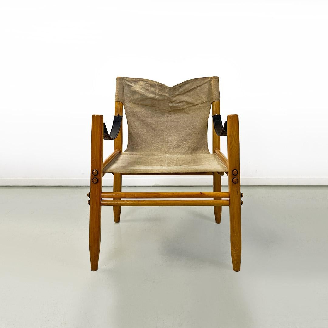 Sessel Modell Oasi 85 oder Safari, mit einem hellen, ineinander greifenden Holzgestell, Sitz und Rückenlehne aus beigefarbenem, grobfaserigem Baumwollstoff, Armlehnen aus Lederriemen und Metallstäbchen.
Produziert von Zanotta um 1960 und entworfen