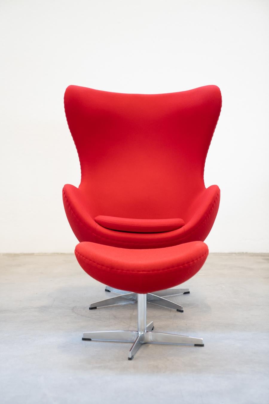 FAUTEUIL EGG CHAIR fauteuil avec ottoman 1980/1990
Conçu par Arne Jacobsen pour Fritz Hansen, Egg possède une structure 	en mousse de polyuréthane renforcée par des fibres de verre. La 	la mousse du rembourrage et le coussin du siège sont en