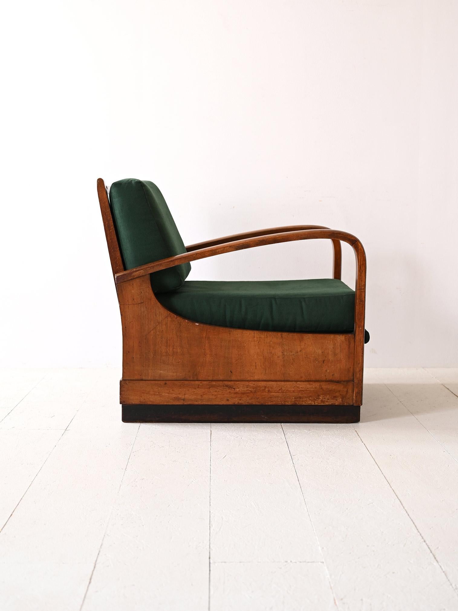 La poltrona Art Deco degli anni '40 incarna una doppia funzionalità: un confortevole sedile che si trasforma in letto. Il legno, con le sue linee curve e la finitura patinata, aggiunge un tocco di storicità, mentre il rivestimento verde è suggestivo