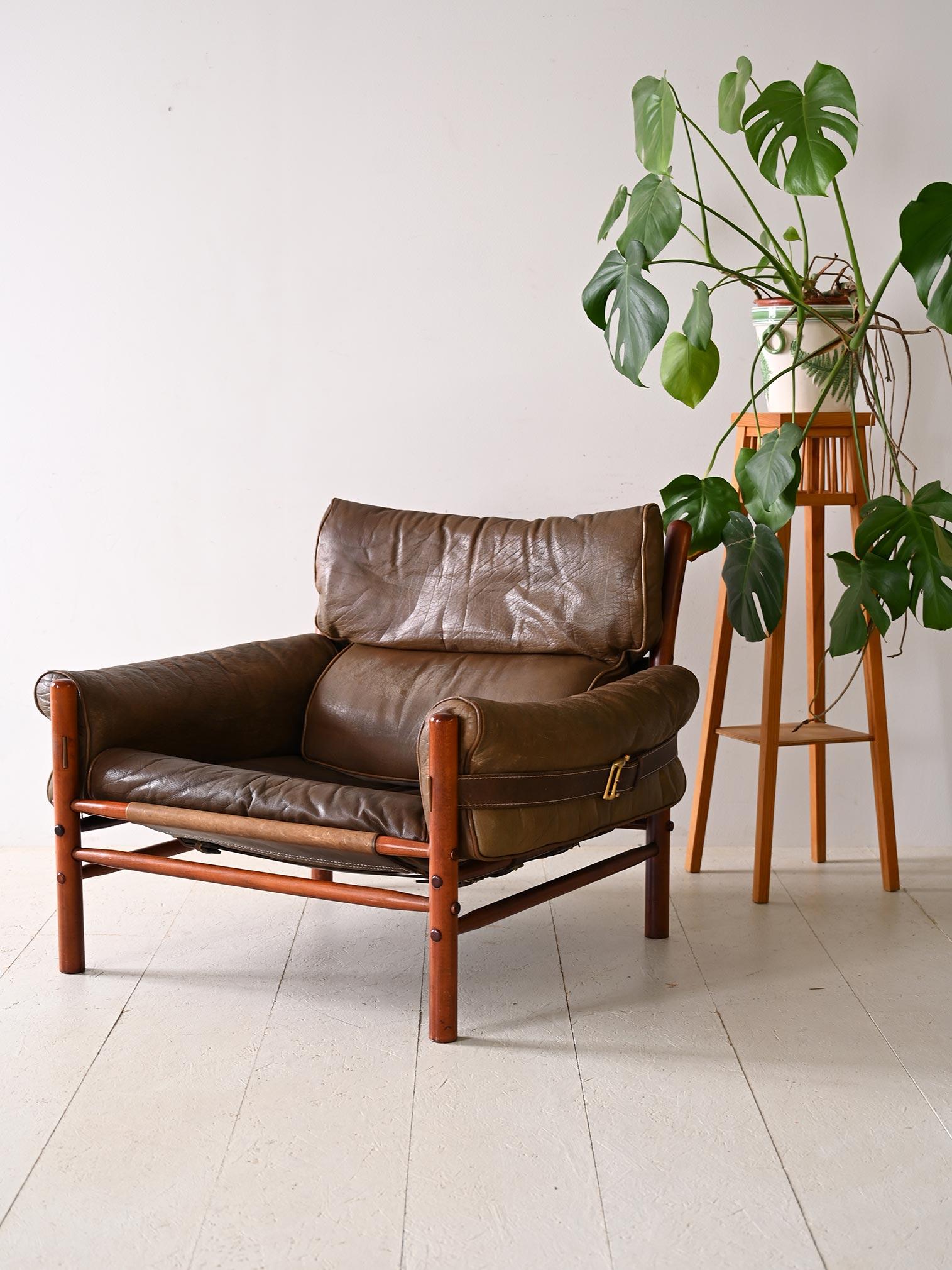Fauteuil scandinave avec assise en cuir. Ce chef-d'œuvre de design allie la beauté chaleureuse du bois et le raffinement du cuir pour créer une pièce qui se distingue par son style distinctif et sa qualité de fabrication. Le cadre en bois constitue