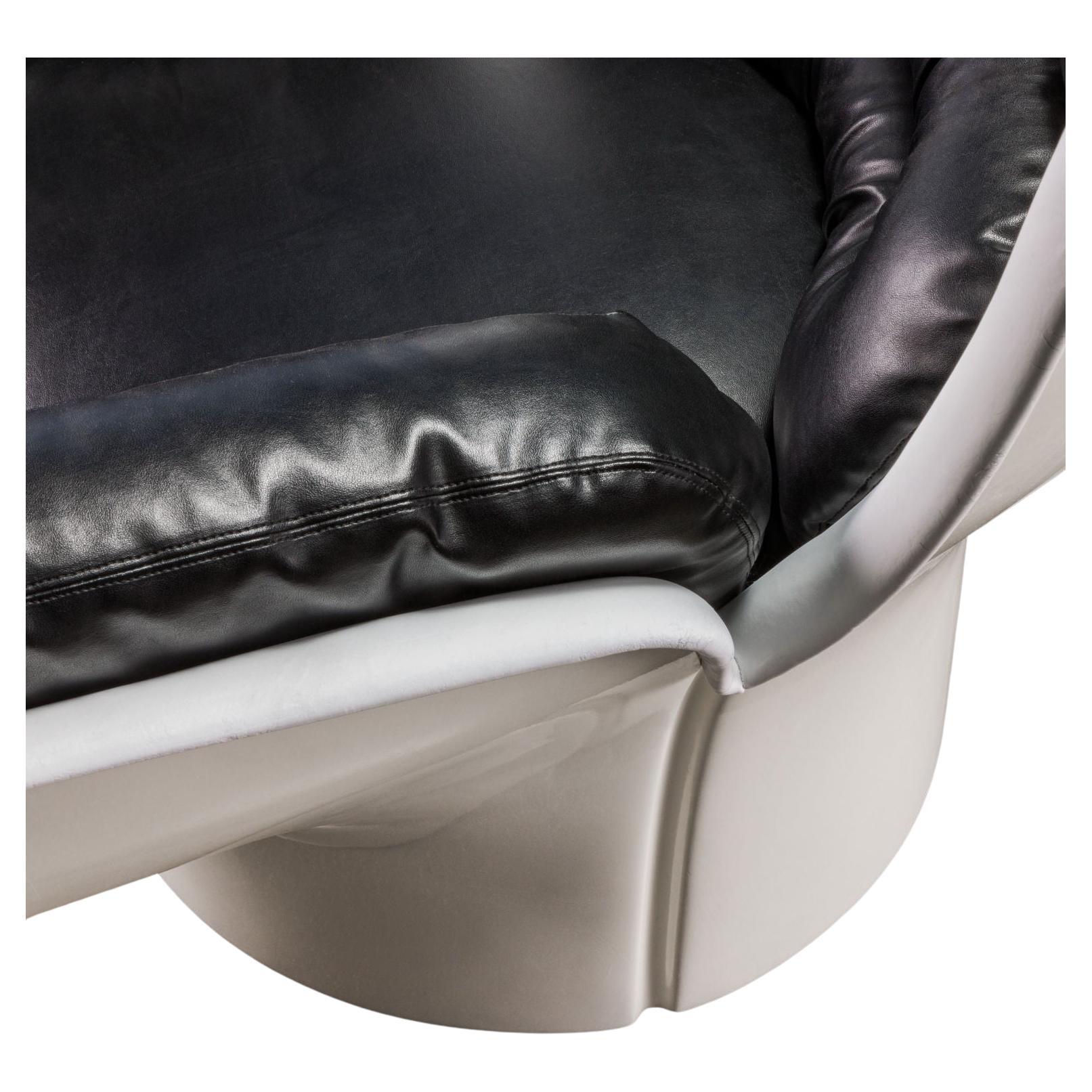 Iconica poltrona modello 'Elda', disegnata da Joe Colombo e prodotta da Comfort a partire dal 1965. Struttura e  scocca in fibra di vetro, seduta e schienale rivestiti da cuscini in pelle nera; base girevole.