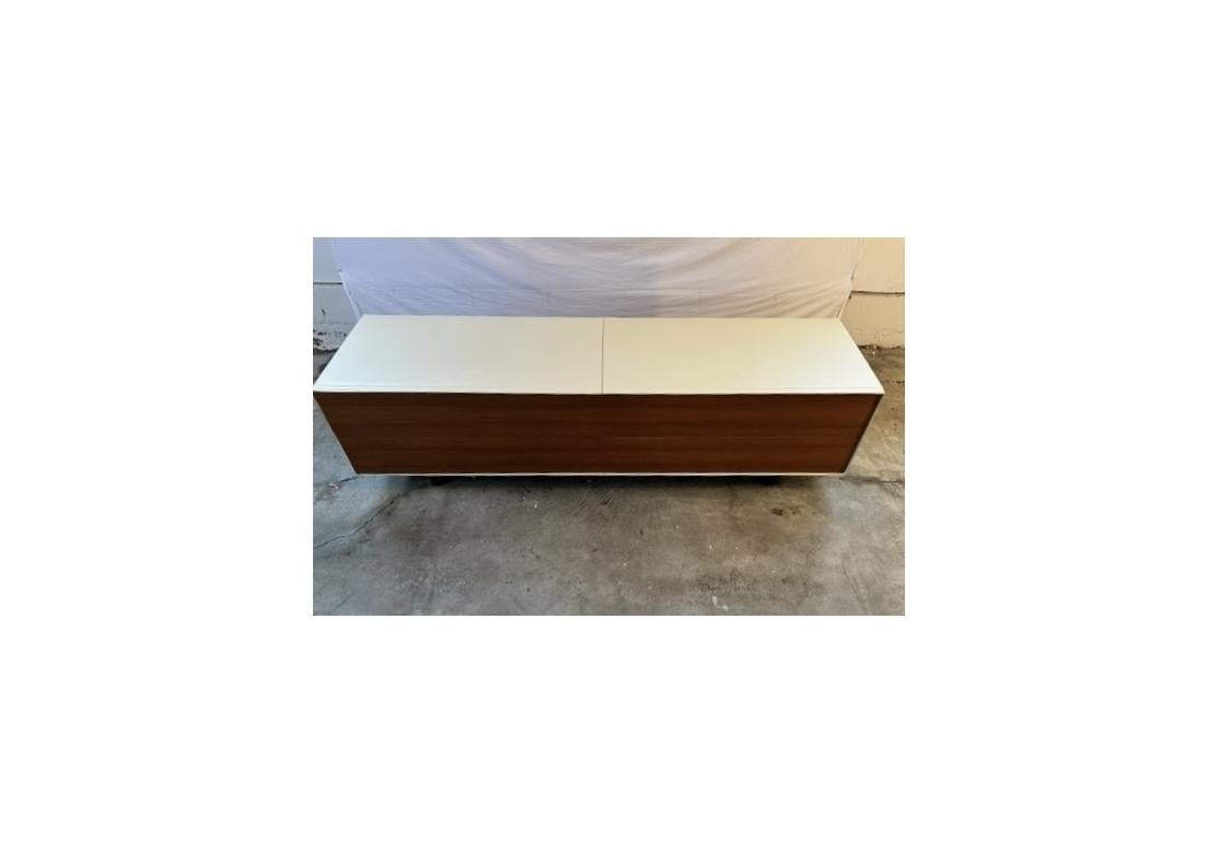 A four drawer low dresser from Italian design firm Poltrona Frau. Wrapped in Cream tone stitched leather and having four push operated Walnut tone wood drawers with a fine satin finish floating on two upright wood panel boards.  The interior drawer