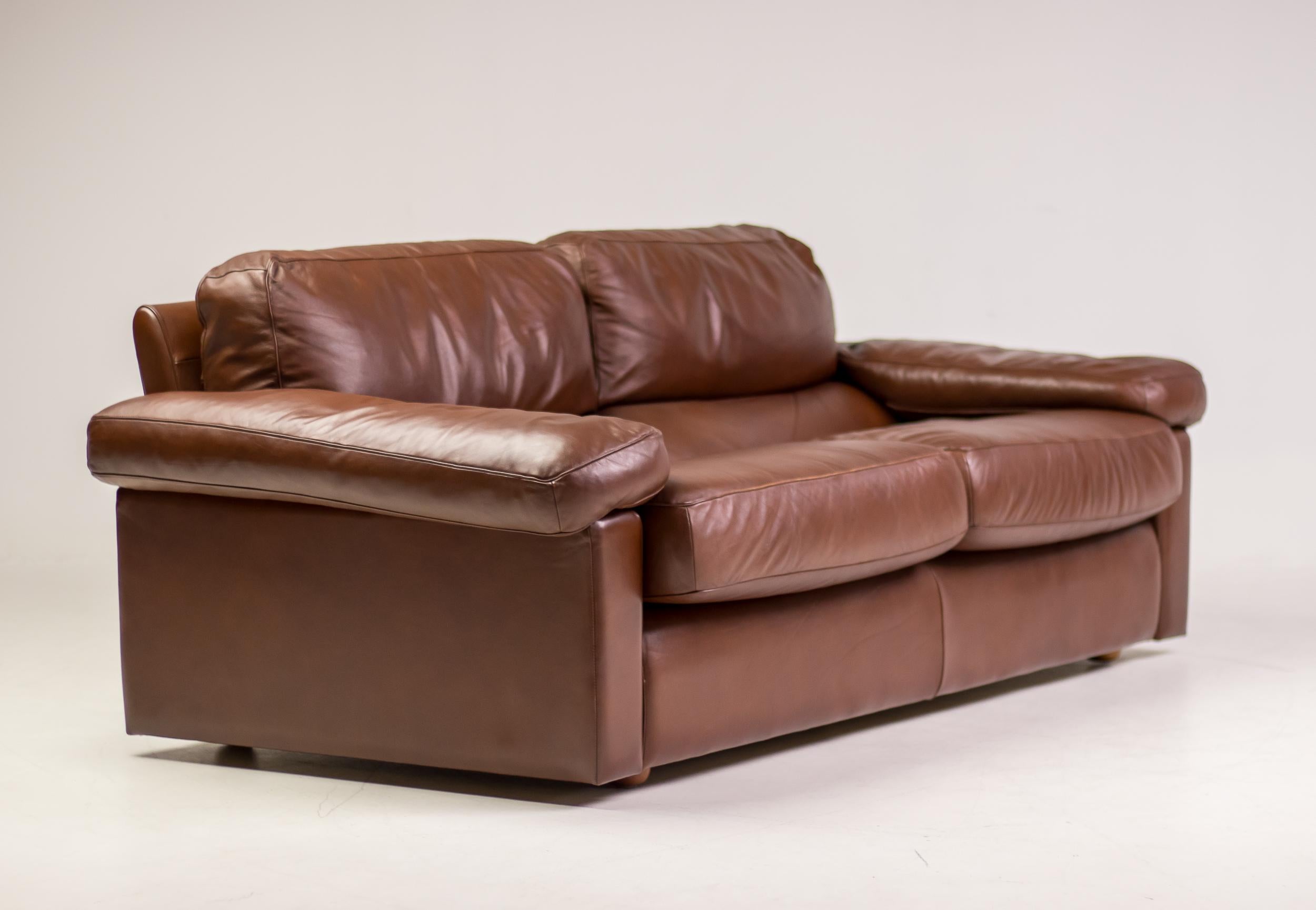 Distinctive Poltrona Frau Petronio sofa from the premium collection in the late 1970s. 
This super comfortable down-filled 2-seater is upholstered in premium quality chestnut leather.
Marked underneath the cushions and in leather of the seat