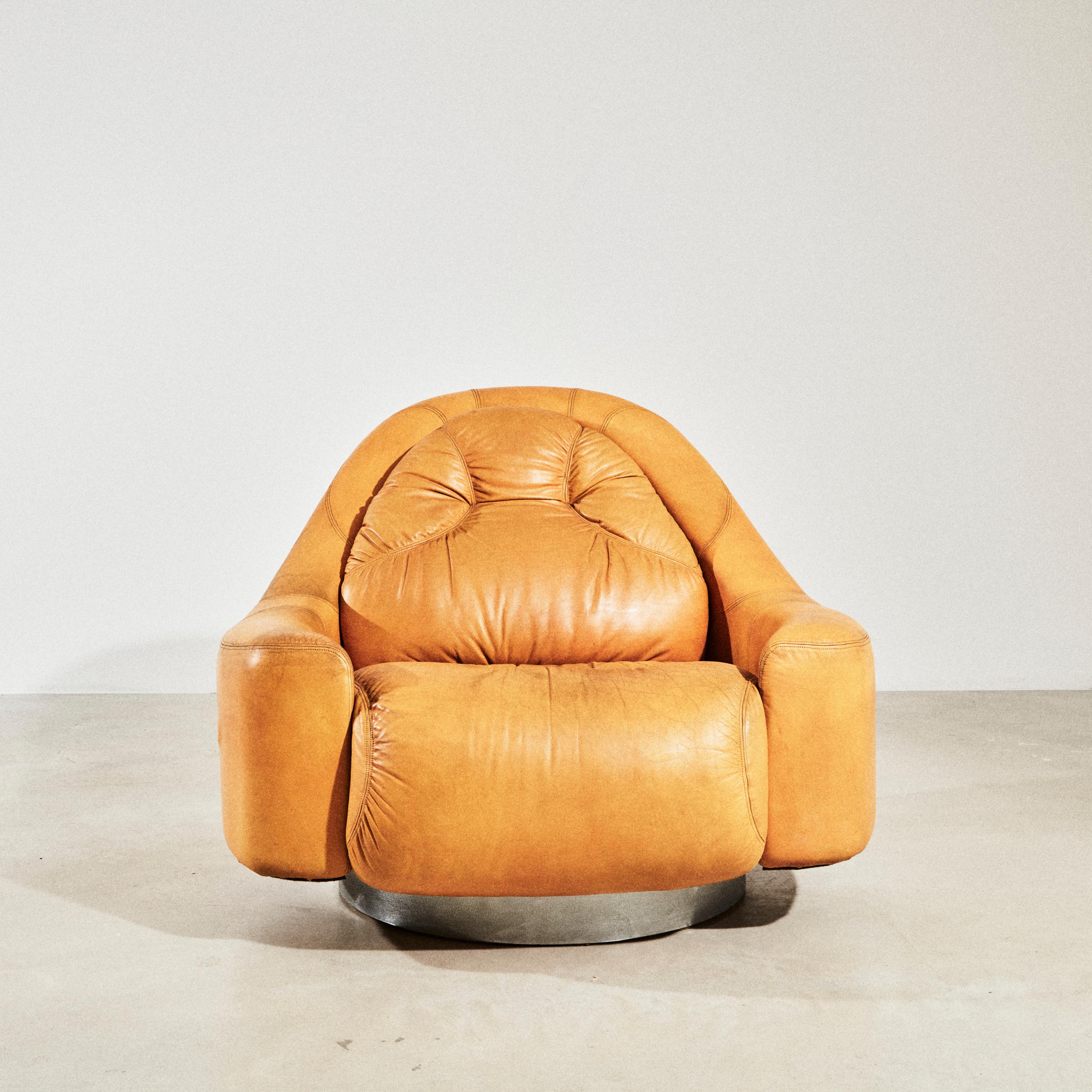 Fauteuil de salon pivotant en cuir avec base circulaire en acier chromé, conçu par Guido Faleschini pour Mariani vers 1975. Les lignes douces, enveloppantes et volumineuses, ainsi que l'utilisation de matériaux précieux, représentent la signature