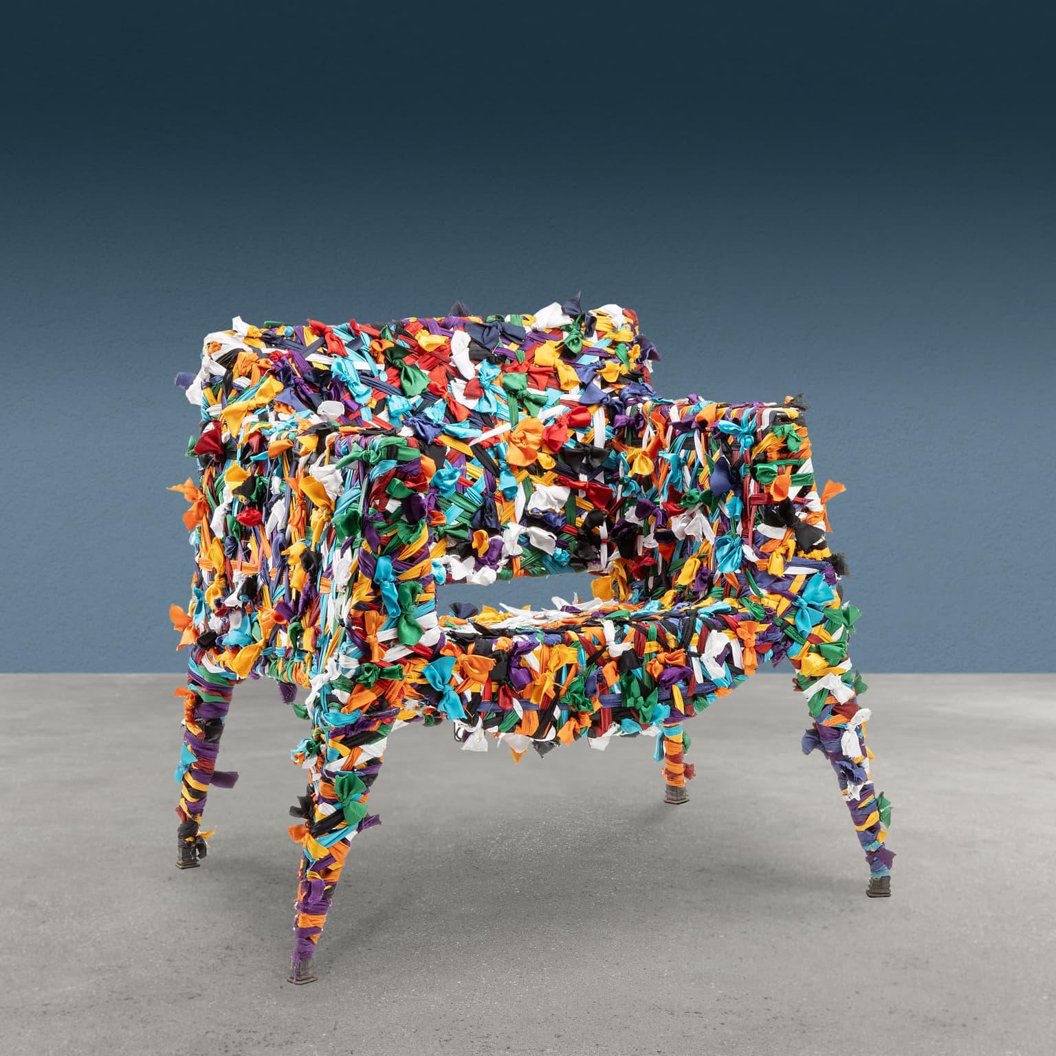 Sillón diseñado y fabricado por Anacleto Spazzapan soldando una varilla de hierro y embelleciéndolo con tela multicolor aplicada mediante la técnica del copo. Asiento con las iniciales del artista perteneciente a la serie 