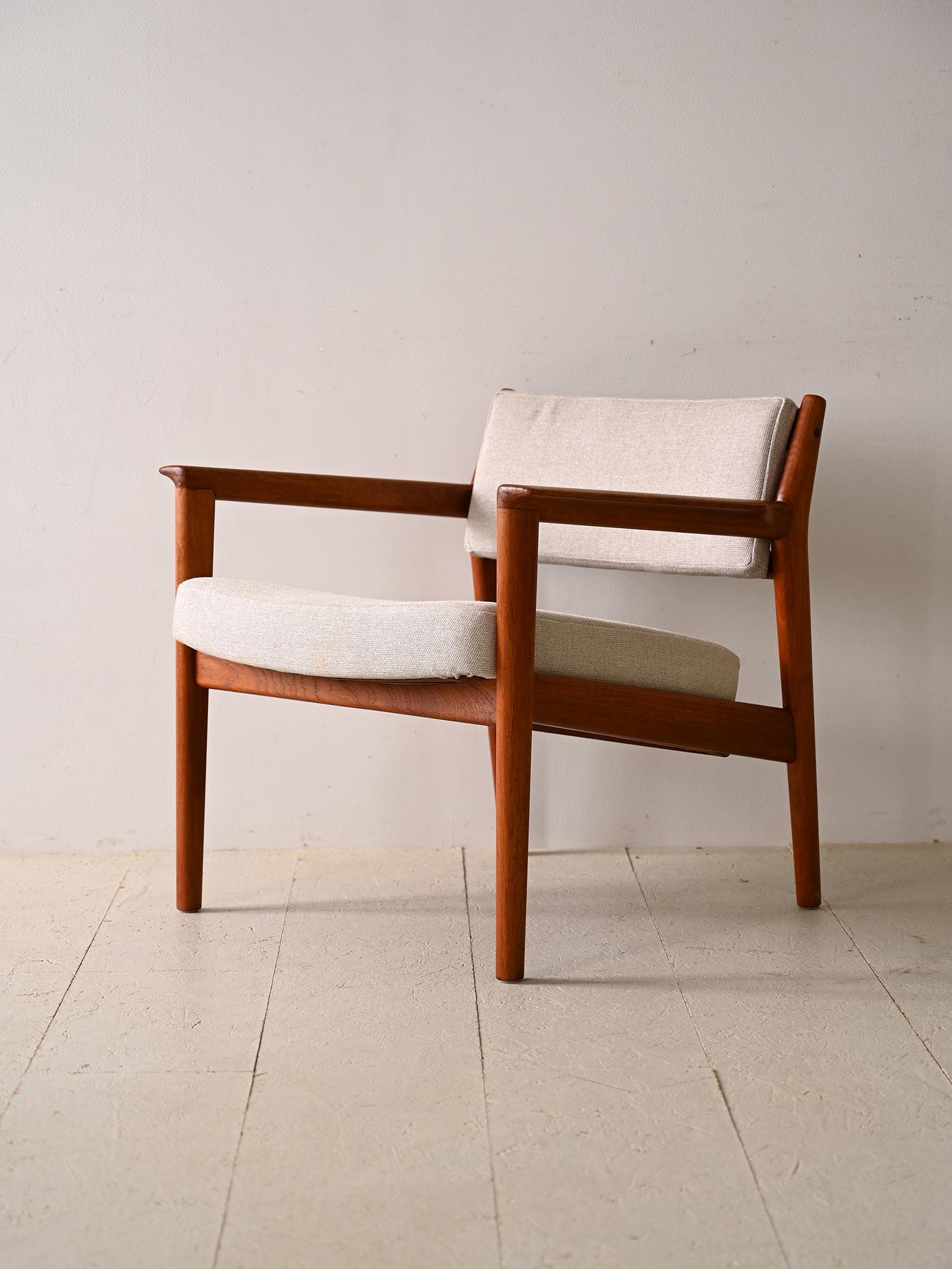 Minimalist teak armchair with upholstered seat. Add a touch of simplicity and sophistication to your space with this armchair with clean lines and timeless design. Made with a high-quality teak frame, this armchair features the slightly sloping seat