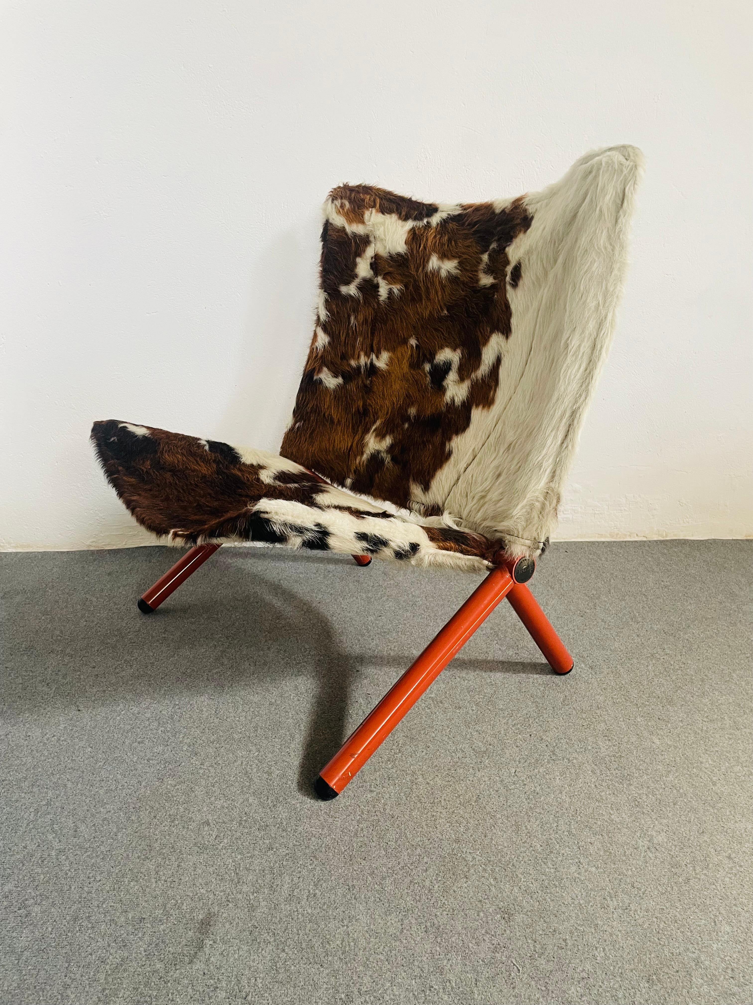 Sedia del 1970 con un'ampia impronta. La sedia è pieghevole e ha una spessa struttura tubolare arancione.
Su di esso si inseriscono lo  schienale e il sedile in Cavallino.
Progettata negli anni '70 da T. Ammannati & G. Vitelli, produzione Vitelli