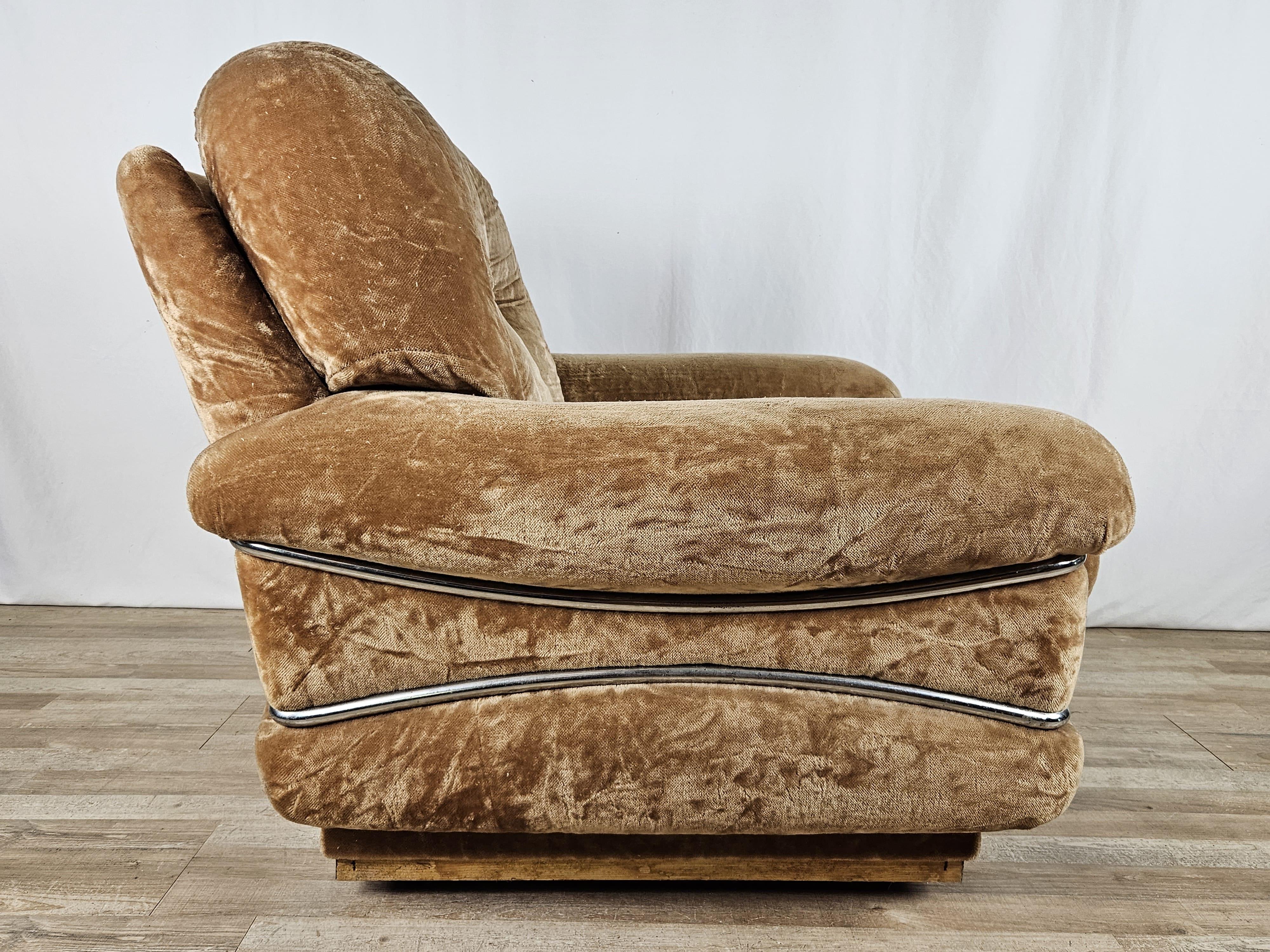 Mid Century armchair upholstered in fabric and decorated with a light steel frame at the sides and base.

The two cushions have removable covers; the seat cushion is missing a button as pictured.
One of the four steel strips at the base is missing.