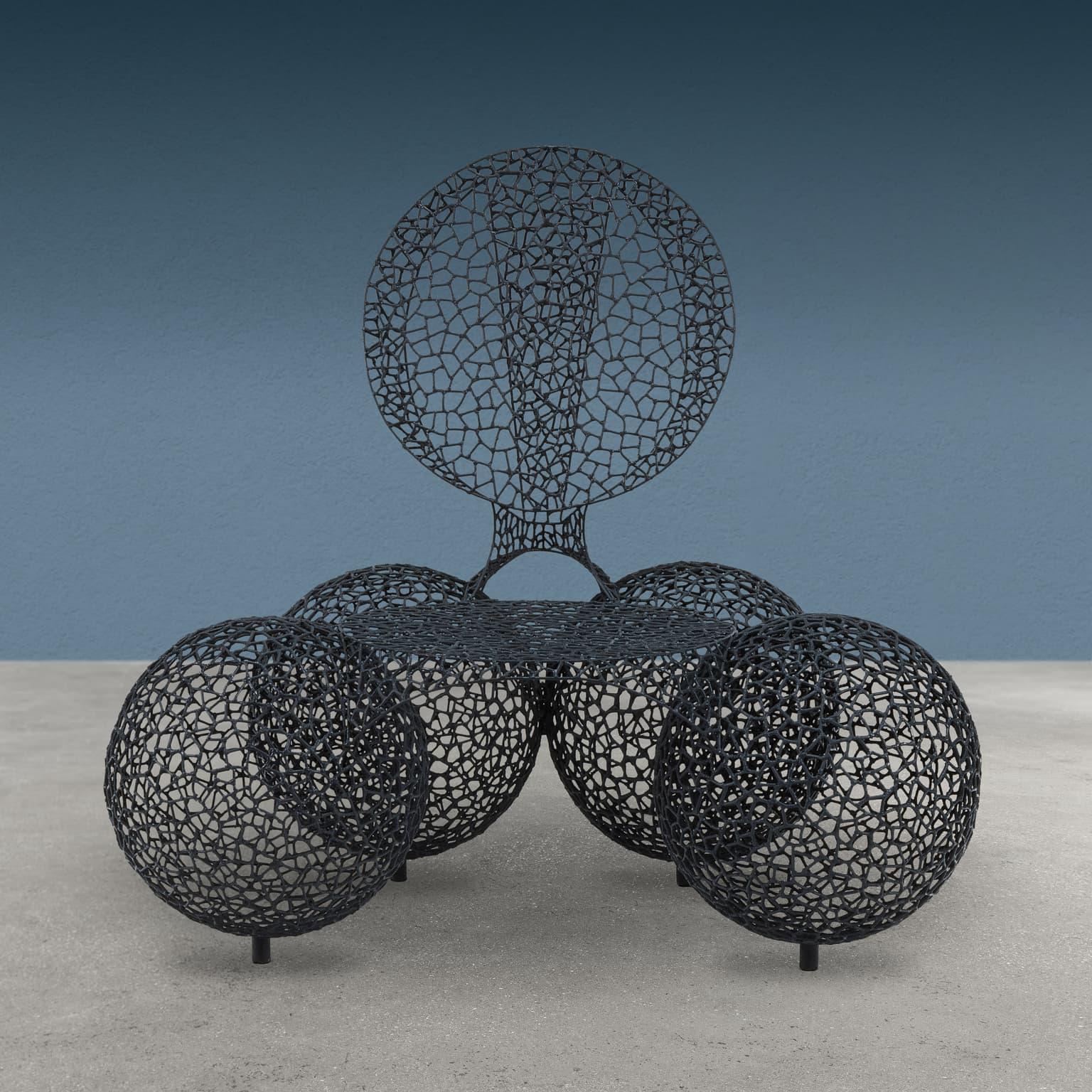 Sillón diseñado y fabricado por Anacleto Spazzapan soldando pequeñas piezas de hierro a partir de una varilla y esmaltándolas después en negro, formado por cuatro esferas unidas por el asiento y el respaldo. Sillón bautizado por el artista con el