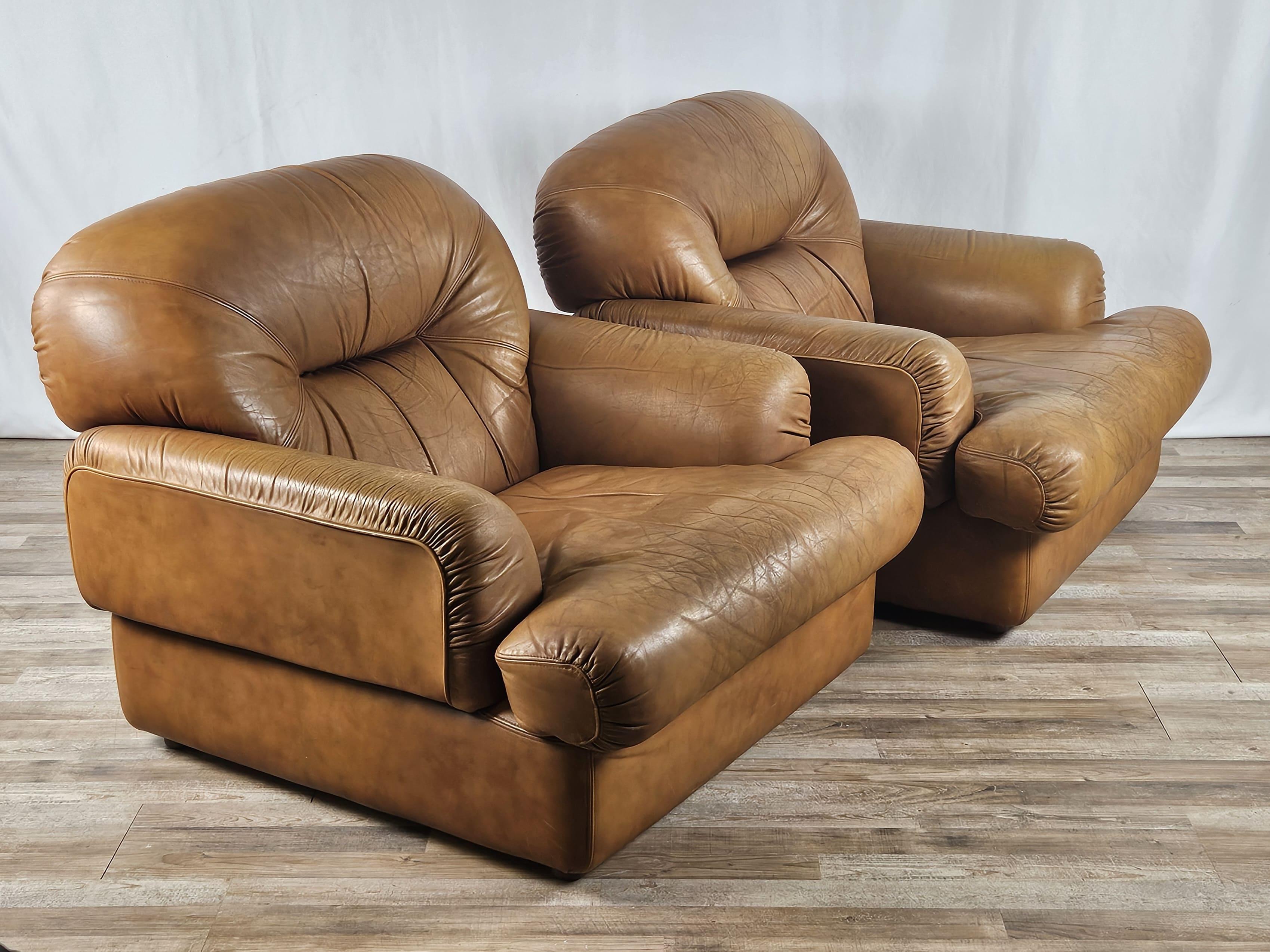 Pair of 1970s leather armchairs, Italian production of high quality and workmanship signed Estasis Milano of Meda (MI).

The armchairs come fully upholstered in a classic cognac color that never goes out of fashion, but rather lends style and