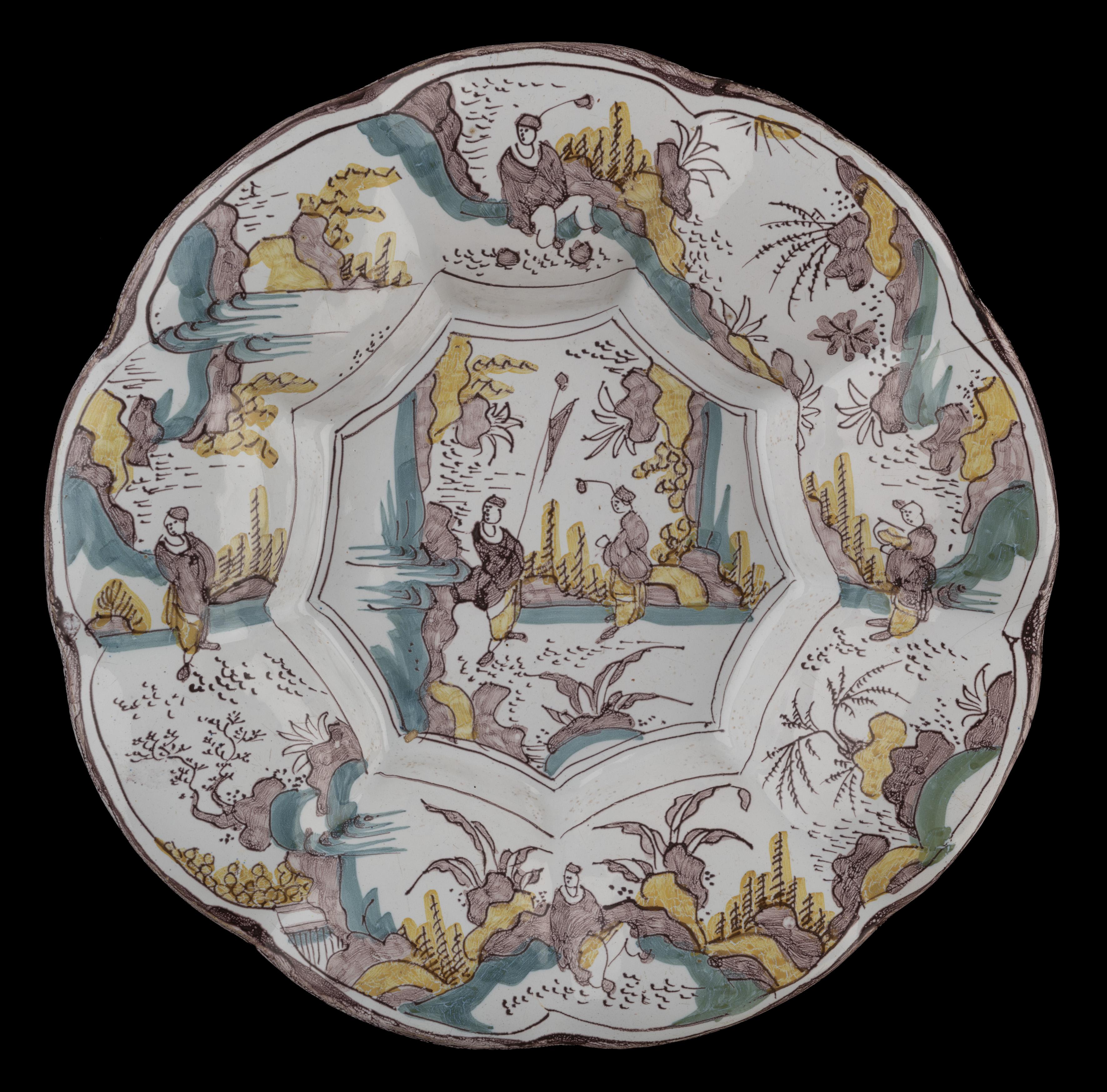 Polychrome chinoiserie lobed dish. Delft, 1680-1690 
The lobed dish is composed of nine wide lobes around a nine-fold centre and is painted with a chinoiserie decor in purple, yellow and green. Two Chinese figures in an eastern landscape are