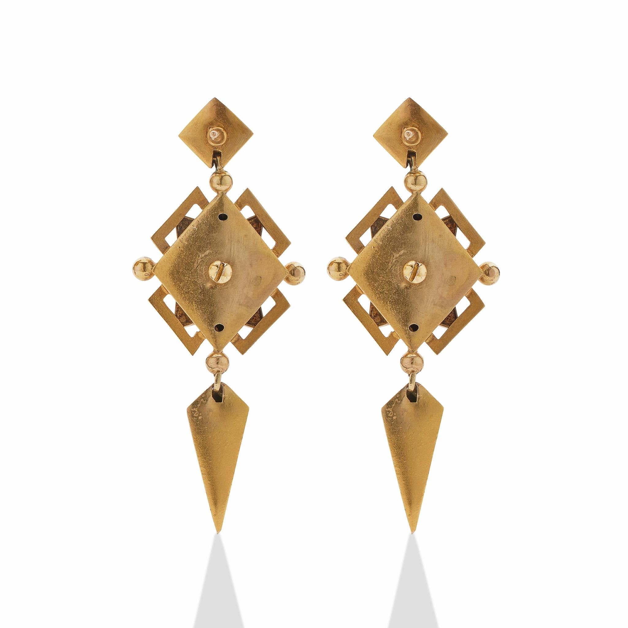 Created in the 1860s, these long antique pendant earrings are composed of 18K gold, enamel and split seed pearls. Each is designed as a navette-shaped top enclosing a hemisphere, suspending flexibly-set stepped, open, and interlocking oval, navette,