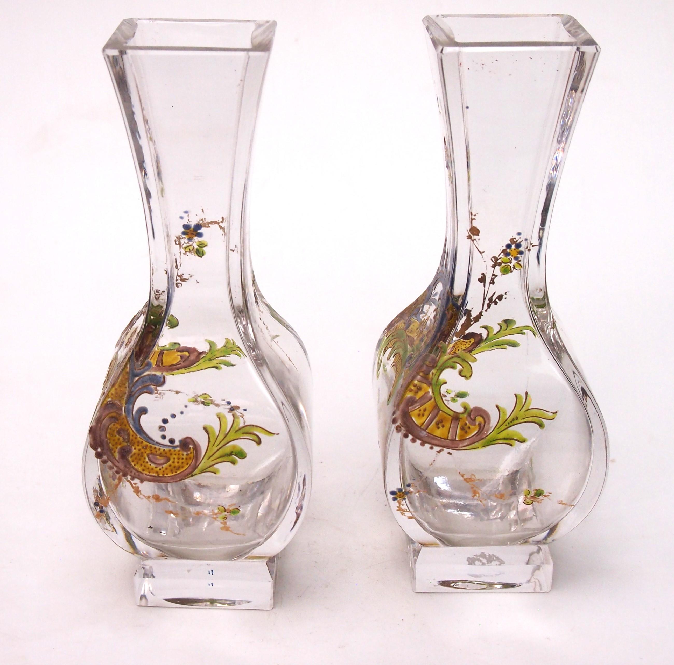 Magnífico par de jarrones de esmalte policromado de Baccarat c 1895, La decoración es el clásico renacimiento rococó con arcos rotos en verdes, azules, amarillos y dorados con rocíos de flores. El jarrón en blanco es una de sus formas más clásicas