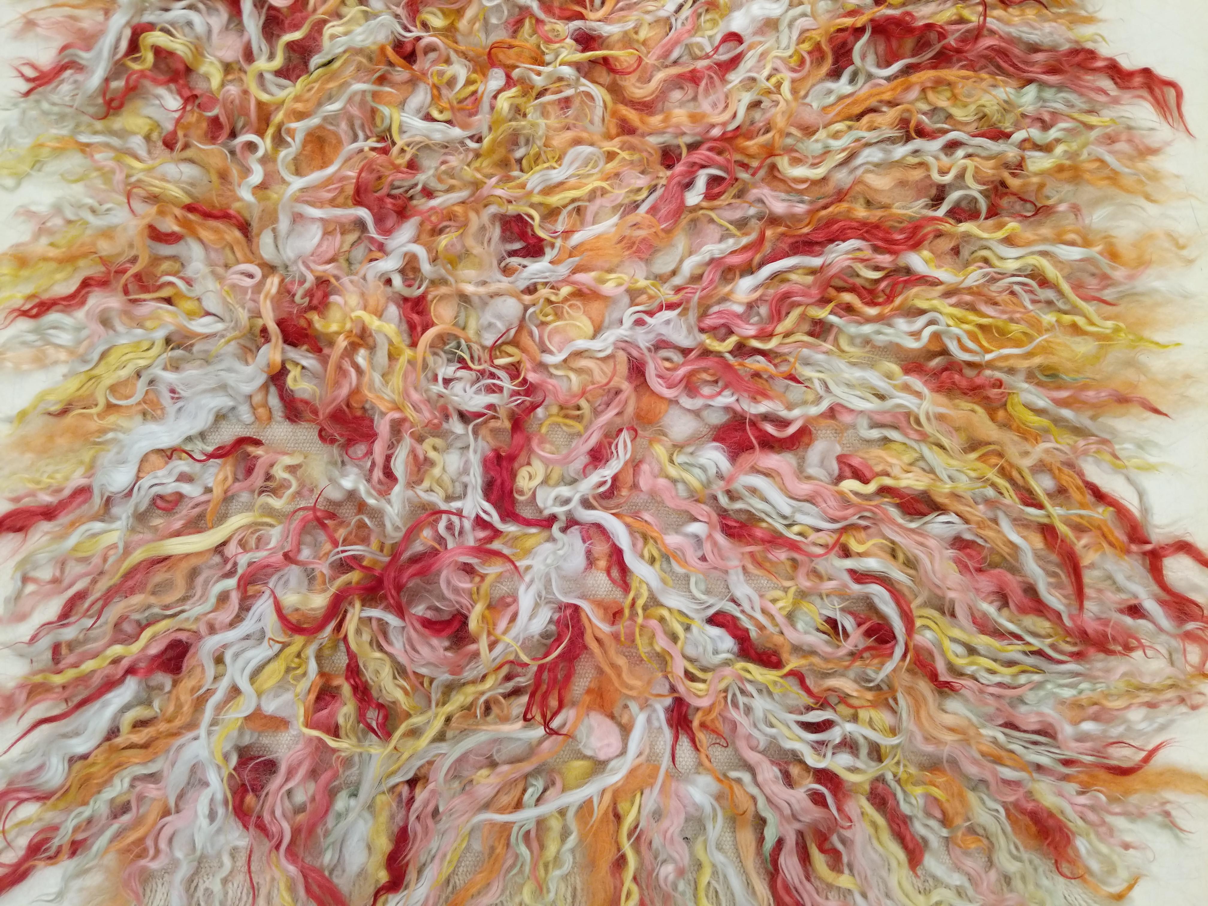 Uno splendido tappeto filikli in formato runner stretto, annodato a mano nell'Anatolia centrale con lana d'Angora filata a mano e tinta naturalmente in varie tonalità di rosso, rosa, giallo e avorio, poi mescolate in modo casuale per ottenere una