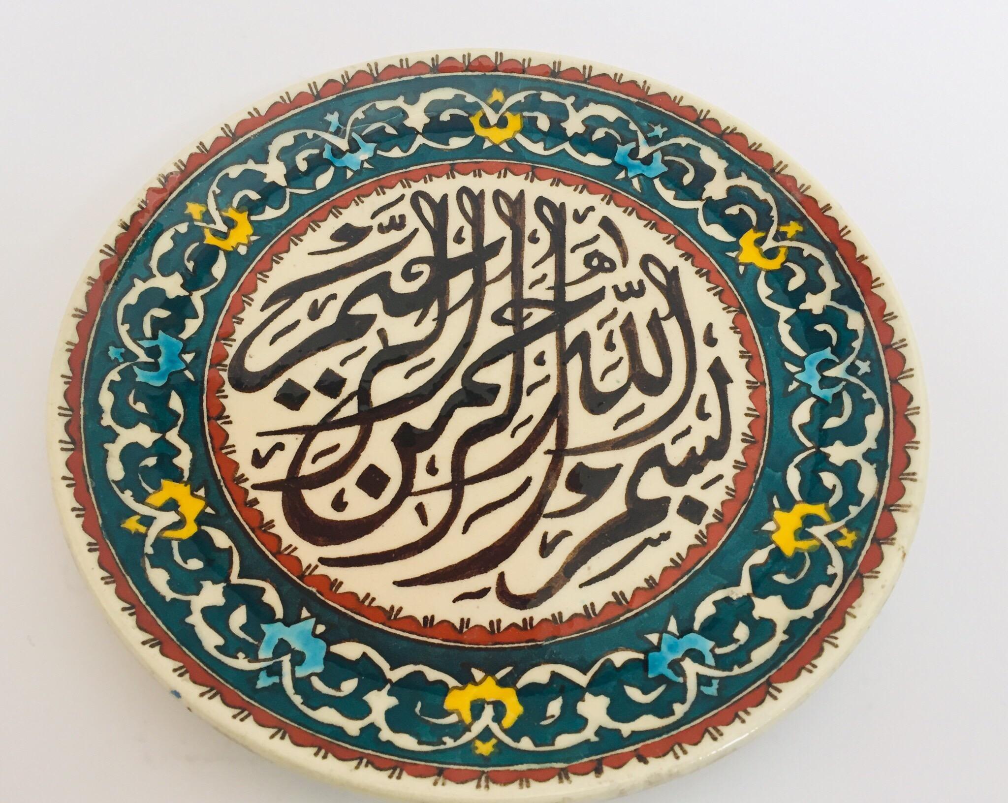 Polychrome hand painted and handcrafted ceramic wall decorative plate with polychrome Ottoman floral design and Islamic calligraphy writing in the centre. 
This is an intricately, hand painted plate that was made in Turkey. 
Turkey is famous for its