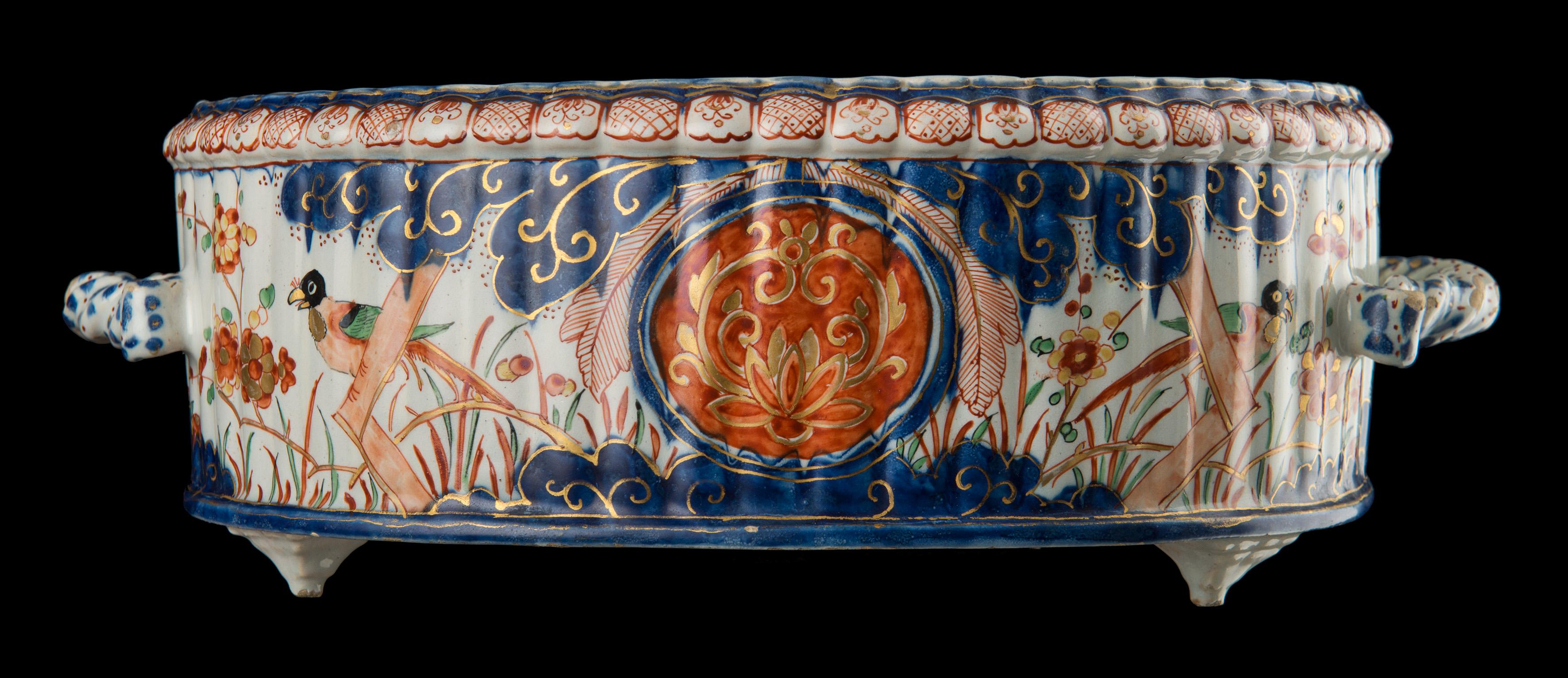 Polychrome Imari cooler. Delft, 1713-1735 
Mark: AR Painter: Adriaan van Rijsselbergh 

This oval ribbed cooler stands on three pyramid-shaped feet and is painted in a six-coloured Imari palette. The exterior is decorated with two round