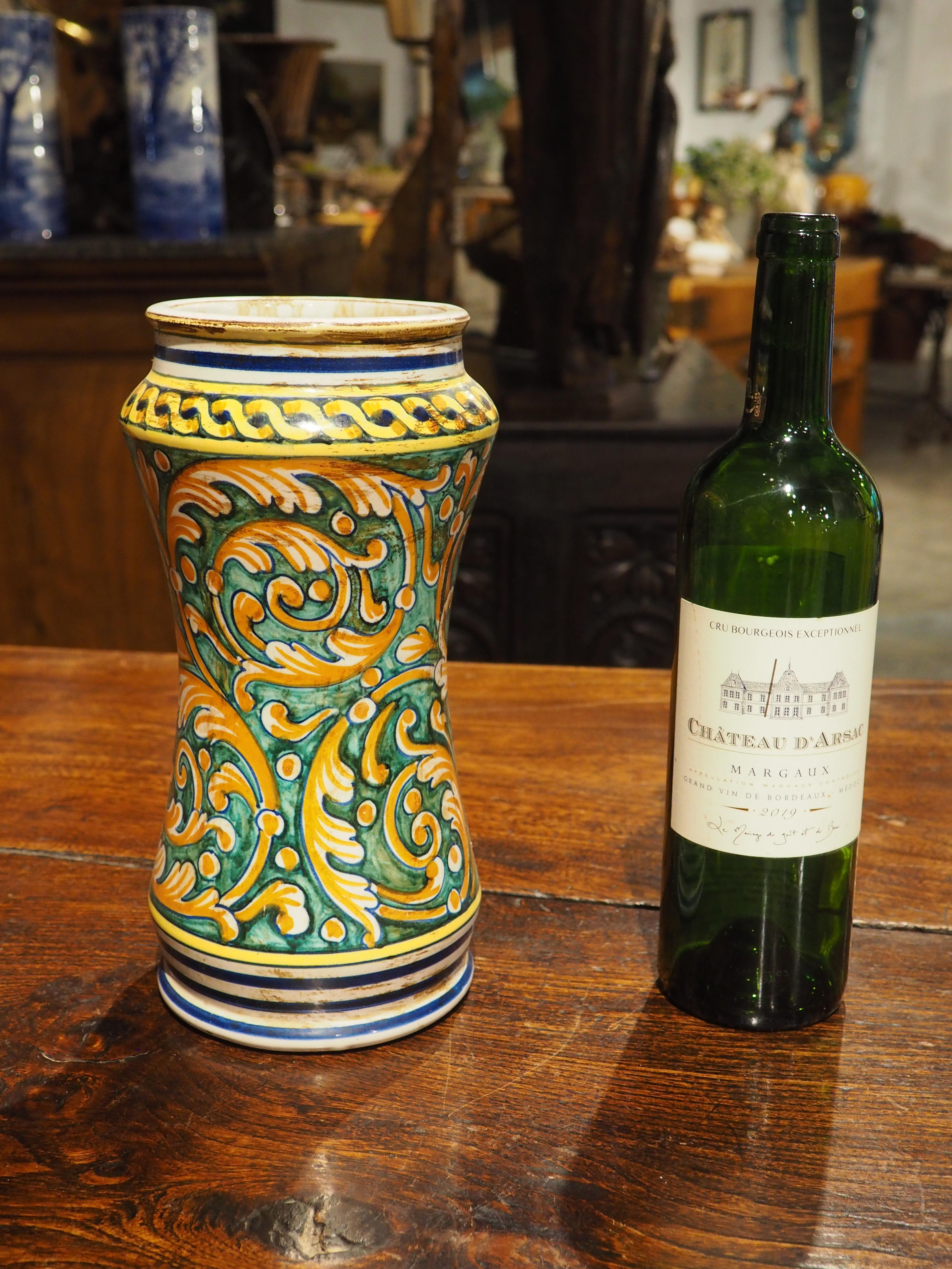 Ulteriori informazioni in arrivo...

Dipinto a mano in Italia alla fine del 1800, questo vaso in albarello policromo ha un fondo verde sotto numerosi rinceaux fogliati in arancione e bianco.  Il collo e il piede sono stati decorati con strisce blu