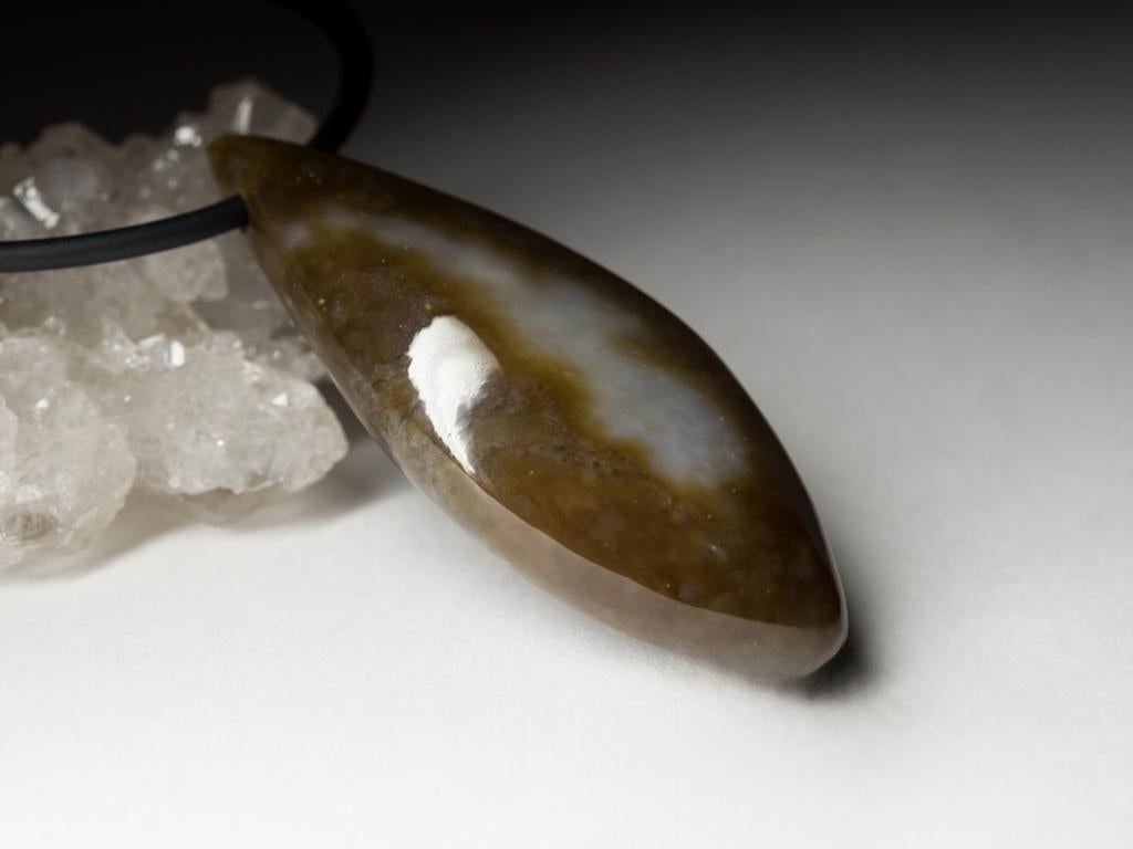 Pendentif artisanal en forme de goutte avec Jade naturel polychrome brun-blanc sur Corde en cuir et caoutchouc
Ce pendentif est orné d'une grande pierre de Jade naturelle en forme de goutte d'eau, dans des tons apaisants de brun et de blanc. Connue